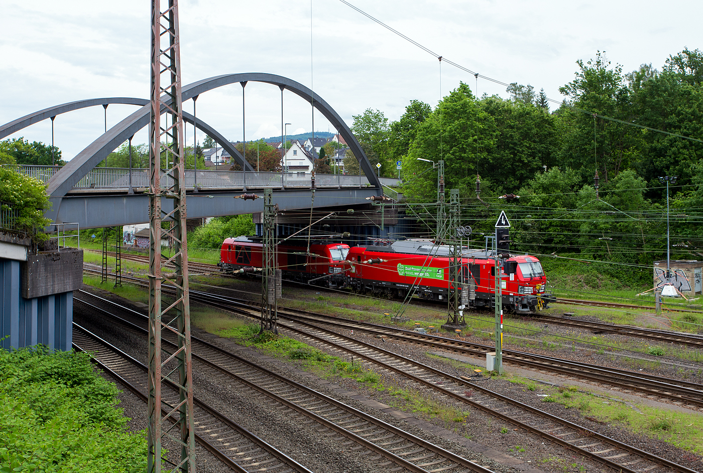 Abgestellt unter der Langenauer Br�cke in Kreuztal (nahe dem Rbf) sind am 21 Mai 2024, von links nach rechts die Loks der DB Cargo AG:
Die beiden neuen Zweikraftlokomotiven „Siemens Vectron Dual Mode light“ (BR 249), vorne rechts die 249 003-5 (90 80 2249 003-5 D-DB) und links dahinter die 249 006-8 (90 80 2249 006-8 D-DB). Beide Vectron DM light wurden 2022 von Siemens Mobility GmbH in M�nchen-Allach unter den Fabriknummern 23061 bzw. 23064 gebaut und waren erst durch Siemens Mobility GmbH als 90 80 2249 003-5 D-SDEHC bzw. 90 80 2249 006-8  D-SDEHC registriert/eingestellt. Die 249 003-5 wurde auch 2022 auf der InnoTrans 2022 in Berlin pr�sentiert. Erst nach der Abnahme durch die DB Cargo und den Verkauf an diese im M�rz 2024 wurde sie durch die DB Cargo eingestellt. Die Loks der Baureihe 249 haben die Zulassung f�r Deutschland und eine H�chstgeschwindigkeit von 120 km/h.

Hinter den beiden Vectron DM light stand noch die remotorisierte V90 – 294 715-8 die man hier nur erahnen kann.
