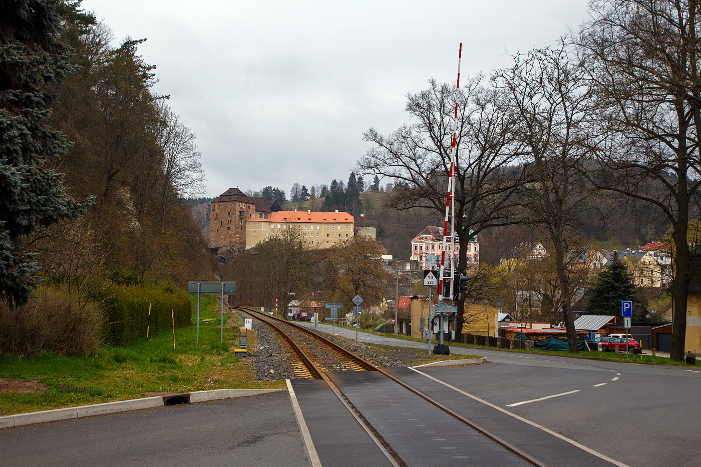 Bečov nad Teplou (Petschau) am 20.04.2023: Blick auf die Bahnstrecke Mariánské Lázně–Karlovy Vary (Marienbad–Karlsbad) – SŽDC 149, hier beim Bahnhof in Richtung Karlsbad gesehen. Hinten das historischen Zentrum des kleinen schönen Ortes mit der Burg und dem Schloss Bečov.