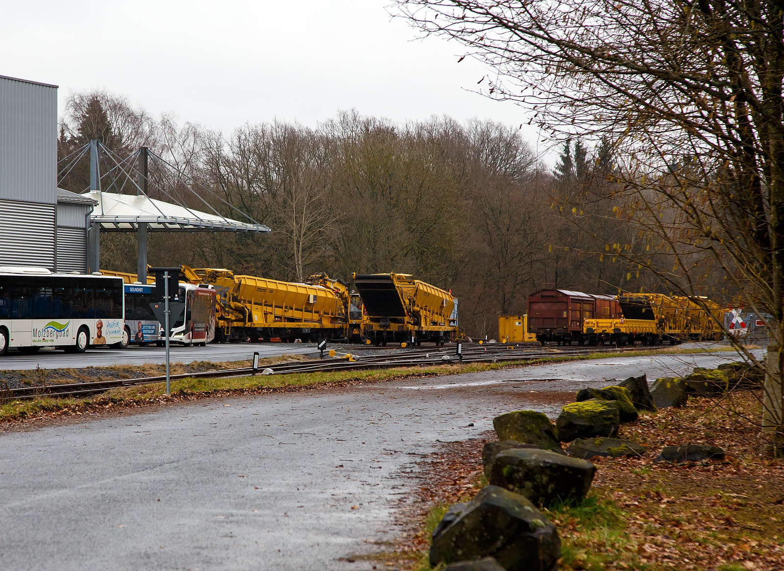 Da keine Lok zur Hand ist (die WEBA hat keine zugelassene Lok mehr) übernimmt ein Liebherr-Zweiwegebagger den Verschub.
Ein Liebherr-Zweiwegebagger der HERING Bahnbau schiebt zwei P&T Materialförder- und Siloeinheiten MFS 38 der HERING Bahnbau am 13.03.2023 vom  Betriebshof der Westerwaldbahn (WEBA) auf der Bindweide bei Steinebach/Sieg in die Werkstatthalle