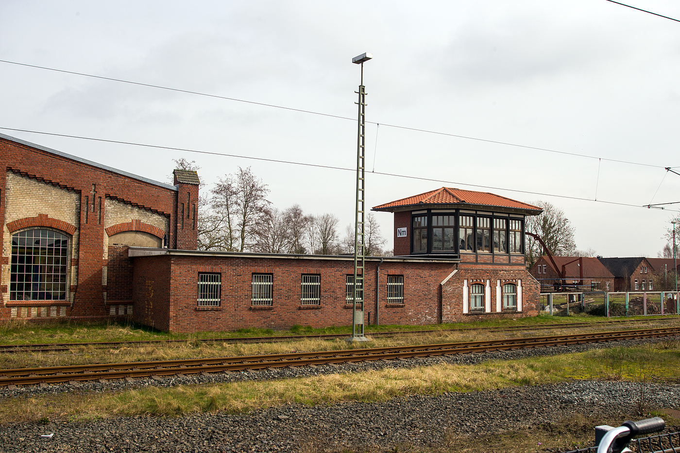 Das Stellwerk Norden „Nm der Museumseisenbahn K�stenbahn Ostfriesland e. V. am 14 M�rz 2024, gleich neben dem Bahnhof Norden.

Zum ehemaligen Betriebswerk Norden geh�rte au�erdem das Stellwerk Norden „Nm“. Dieses wurde mit der Inbetriebnahme des neuen Stellwerks „Nf“ am 20. Oktober 1954 au�er Dienst gestellt und sp�ter bis auf den Unterbau abgebrochen.
 
Im Rahmen einer A&L-Ma�nahme konnte das nur noch als Sockel vorhandene ehemalige Stellwerk wieder aufgebaut wurden. Es gibt einen Einblick in das Zeitalter der mechanischen Stellwerke, die mittels Drahtzugleitungen f�r das Legen von Fahrstra�en sowie die dazugeh�rige Signalisierung zust�ndig waren. Heute k�nnen Besucher im Stellwerk „Nm“ diese alte Technik erleben und ausprobieren. Die ausgestellte Technik stammt vom Stellwerke Marienhafe S�d (Ms).
