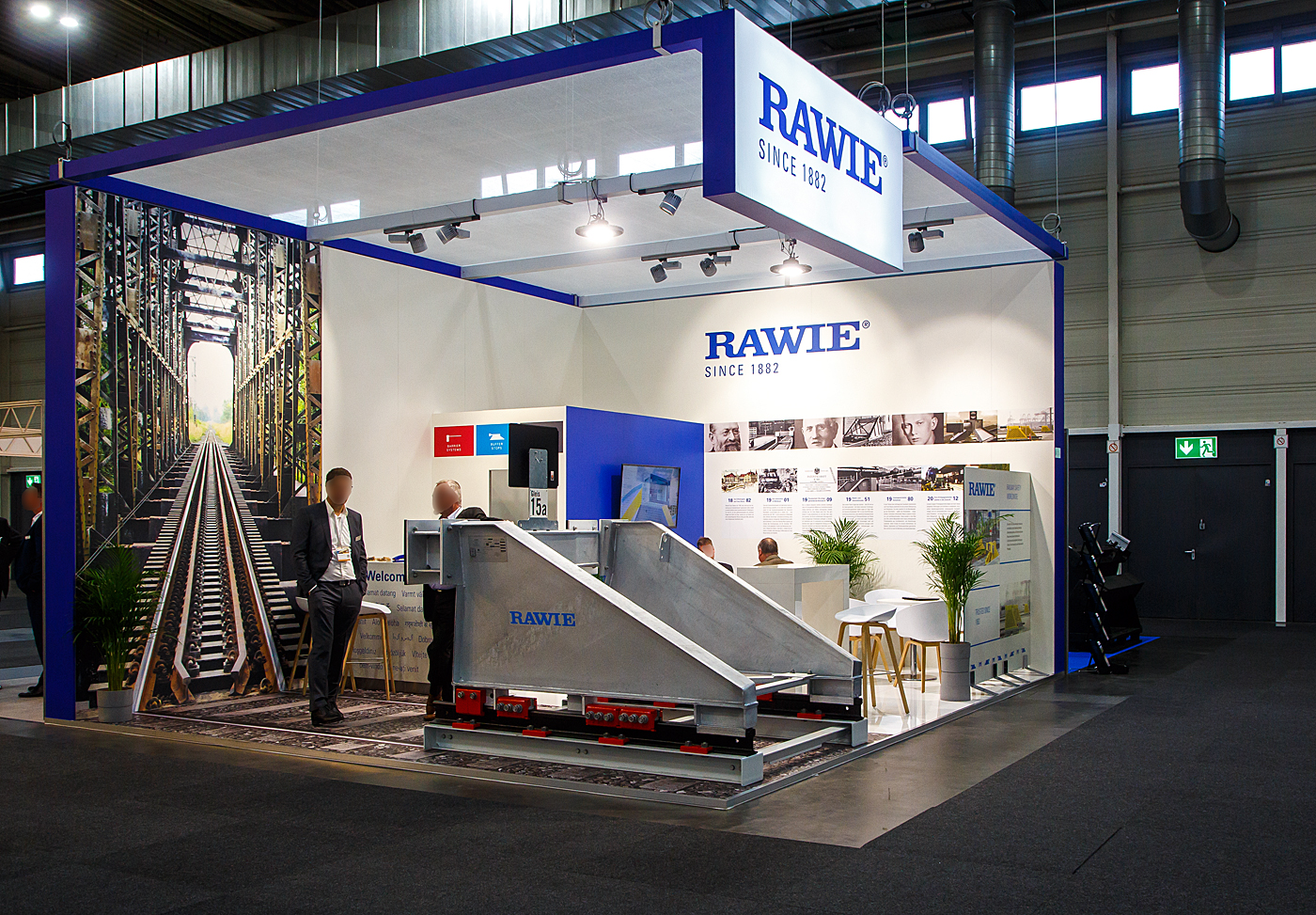 Das wusste ich auch nicht, der Ingenieur Franz Rawie aus Osnabrück ist der Erfinder des Prellbocks. Heute die A. RAWIE GMBH & CO. KG, diese hatte auch einen Stand auf der 28. Internationale Ausstellung Fahrwegtechnik 2022 (iaf) in Münster, hier am 31 Mai 2022, und stellte auch einen Brems-Prellbock aus. 

Bremsprellböcke können deutlich höhere Energien als alle Arten von Festprellböcken aufnehmen. Sie werden in der Regel auf den Fahr- und gegebenenfalls Zusatzschienen mit speziellen Klemmen befestigt, die untereinander mit Schrauben verspannt sind. Diese Klemmen erzeugen eine hohe Reibung und können so beispielsweise einen Zug mit einer Masse von 850 Tonnen auf sieben Metern von 15 km/h bis zum Stillstand abbremsen, ohne die Fahrzeuge zu beschädigen. Ist mit höheren Massen oder Geschwindigkeiten zu rechnen, wird ein Bremsprellbock zusätzlich mit Schleppschwellen ausgerüstet. Diese erfordern jedoch eine Betonplatte als Untergrund und damit einen deutlich höheren Bauaufwand.

Entwickelt und patentiert wurde der Bremsprellbock von Ingenieur Franz Rawie aus Osnabrück, der nach dem Eisenbahnunfall im Centralbahnhof Frankfurt nach einer Lösung zum sicheren Abbremsen von Zügen suchte. Am 06. Dezember  1901 fuhr eine Lokomotive mit dem Ostende-Wien-Express (Zugleiter des Orientexpresses) mitten in die gedeckten Tische des Restaurants der 1. und  2. Klasse vom Centralbahnhof Frankfurt a.M., verletzt wurde keiner, ab der war der Anlass zur Erfindung von Franz Rawie. Bereits 1907 erprobte er sein Bremssystem „Nummer 1“ im Bahnhof Ibbenbüren. Da die Bahn keine ihrer Lokomotiven für den Versuch hergeben wollte, beschleunigte man einige alte Güterwagen durch Pferde und ließ sie auf den Bremsprellbock auflaufen, der sie wirksam abbremste. Danach wurden in den Bahnhöfen Schneidemühl, Duisburg und im Bremer Bahnhof in Osnabrück weitere Bremsprellböcke zu Testzwecken aufgestellt. Nachdem alle Versuche mit dem Bremsprellbock zufriedenstellend ausgefallen waren, wurde 1910 der Frankfurter Hauptbahnhof als erstes mit ihnen ausgestattet.
