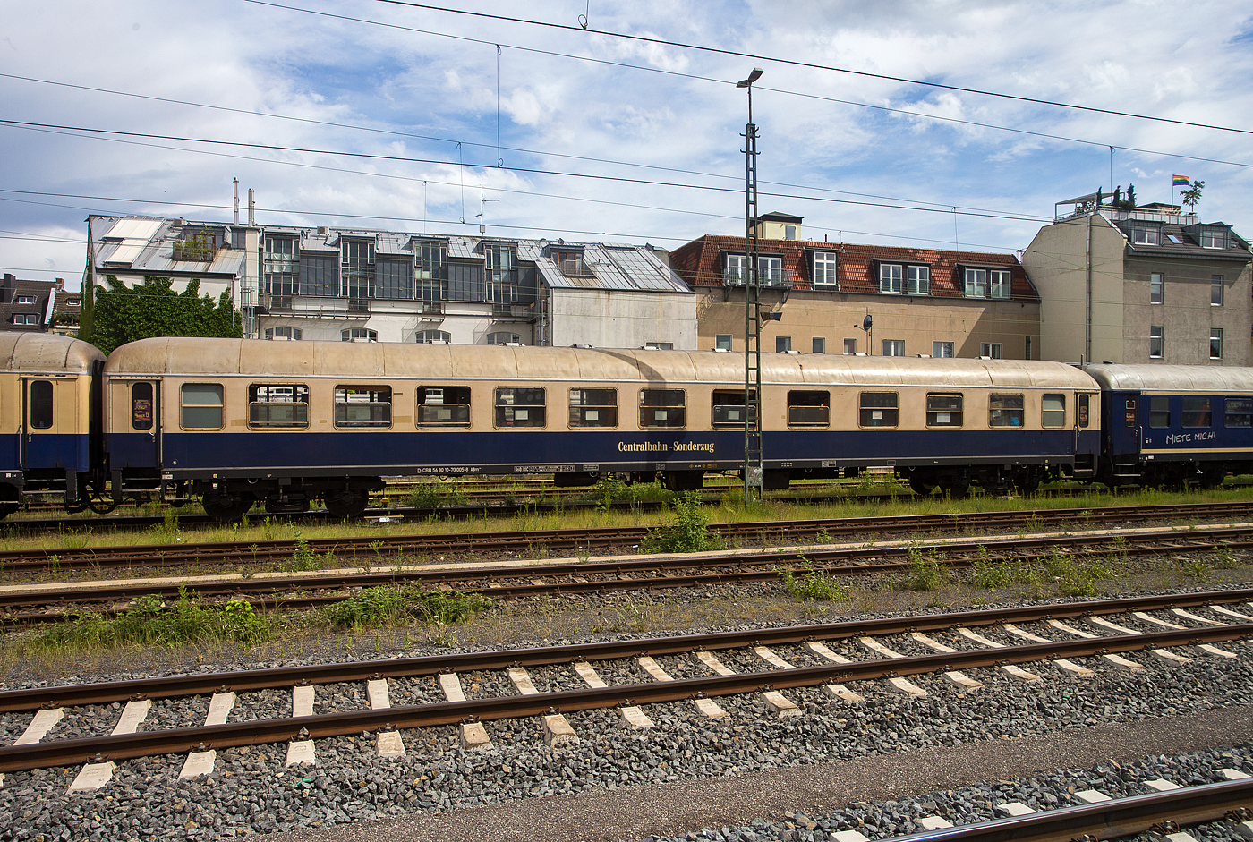 Der 1./2. Klasse Reisezugwagen (Abteilwagen) D-CBB 56 80 10-70 005-8 der Gattung ABm 225 der Centralbahn GmbH (Mönchengladbach), eingereiht im Zugverband eines mit 12 Wagen sehr langen Sonder- oder Partyzug der CBB, am 16 Mai 2024 in Köln-West, aufgenommen aus einen Zug heraus.

Der Wagen wurde 1973 von der Waggon Union (WU) in Berlin-Borsigwalde, als UIC-X Schnellzugwagen der Gattung ABüm 225 für die Deutschen Bundesbahn (DB) gebaut und bekam die Nummer D-DB 51 80 31-70 189-0.
