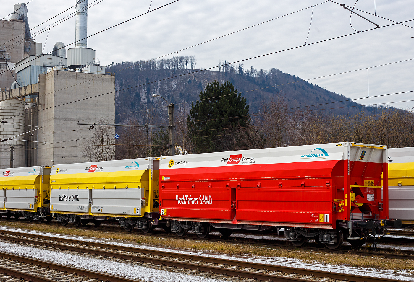 Der 2 x 4-achsige Flachwagen in Sonderbauart (Doppelwagen) bzw. ein 8-achsiger Containertragwagen, 35 81 4854 454-9 A-IF, der Gattung Sggrrs
80 ft, der �sterreichischen INNOFREIGHT bzw, Rail Cargo Austria, abgestellt am 14 Januar 2025 beim Bahnhof Gmunden bzw. beim Zementwerk Hatschek in Gmunden der Rohrdorfer Zement GmbH. Die achtachsige Wageneinheit (80ft Sggrrs IW) ist f�r den Transport von Ladegut mit Ladegestellen geeignet, hier in der Variante J - RockTainer SAND mit einer ISO-L�nge von 40‘

Grunds�tzlich besteht ein InnoWaggon aus zwei kurzgekuppelten Einzelwagen. Leichtbauweise und hohe Belastbarkeit differenzieren diese Waggons dabei klar von anderen und erm�glichen deutlich h�here Zuladung f�r den Transport von unterschiedlichsten G�tern. Der Einsatz der Spezialbeh�lter wird dabei der jeweiligen Branche angepasst, da die Beh�lter je nach Anforderung wie spezifisches Sch�ttgewicht oder Entladestation eingesetzt werden. Hier in der Variante “J” des InnoWaggon mit dem Beh�lter „RockTainer SAND“ ist f�r den Transport von n�sseunempfindlichen Sch�ttg�tern wie Sand und Kies geeignet. Sie umfasst 2 St�ck oben offene Ladegestelle vom Typ „RockTainer SAND“ mit ausschwenkbaren Seitenklappen und fixen Stirnw�nden.Die Beladung erfolgt stets von oben. Die Entladung �ber die Seitenklappen erfolgt schlagartig nach unten seitlich am Waggonrahmen vorbei, in einen Tiefbunker. Ein Ladegestell darf nur mit einem ReachStacker oder Portalkran mittels oberer Eckbeschl�ge manipuliert werden.

Mit einer maximalen Zuladung von 134,4 Tonnen pro Doppelwagen k�nnen gro�e Mengen problemlos transportiert werden. Das ist mit herk�mmlichen Containern oder auf LKWs unvorstellbar. Die Entladung erfolgt in einen Tiefbunker.

Die Rohrdorfer Unternehmensgruppe nutzt f�r die Lieferung von Kalkstein vom Steinbruch Ebensee in das Zementwerk Gmunden die neuen RockTainer SAND-Tragwagen der �sterreichischen �BB Rail Cargo Group (RCG), dem f�hrenden Bahnlogistiker in Europa. Die Spezialtransportwaggons wurden von der RCG in Zusammenarbeit mit der Rohrdorfer Unternehmensgruppe und Innofreight, ein �sterreichisches G�tertransport- und Logistikunternehmen, entwickelt, um mehr Ladung mit weniger Fahrten transportieren zu k�nnen. Seit Mai 2023 werden die 20 neuen, sogenannten InnoWaggons mit 40 RockTainer SAND-Containern auf der ca. 15 km langen Strecke Ebensee–Gmunden (Teilst�ck der „Salzkammergutbahn“ (�BB 170) Bahnstrecke Stainach-Irdning �ber Attnang-Puchheim nach Sch�rding). eingesetzt. Insgesamt werden in diesem Verkehr je Transportperiode rund 450.000 Tonnen Kalkstein bef�rdert. Das sind 36.000 Lkw-Fahrten, die jedes Jahr dank der umweltfreundlichen Schiene und des innovativen Equipments eingespart werden k�nnen.

TECHNISCHE DATEN des 2x40 ft InnoWaggon mit RockTainer SAND:
Gattung: Sggrrs
Gattungskennzahl: 4854
Hersteller: Tatravagonka Poprad (Slowakei), 1. Serie – Wagen 4854 001 bis 090
TS Hungaria Kft. in Miskolc/Ungarn (zum �BB-Konzern)
Spurweite: 1.435 mm (Normalspur)
Achsenanzahl: 8 pro Doppelwagen (in 4 Drehgestellen)
L�nge �ber Puffer: 26.620 mm 
Breite: 2.878 mm
Drehzapfenabstand: 2 x 8.070 mm
Achsabstand in den Drehgestellen: 1.800 mm
Raddurchmesser: 920 mm (neu)
L�nge Ladefl�che: 2 x 12.370 mm (2 x 40 ft)
H�he der Ladefl�che �ber SOK: 1.155 mm
Eigengewicht: 45.700 kg
Max. Geschwindigkeit: 100 km/h (beladen) / 120 km/h (leer)
Max. Zuladung pro Doppelwagen: 143,3 t (ab Streckenklasse D 3)
Bremse: KE-GP-A (K)
Bremssohle: Jurid 822
Kleinster befahrbarer Gleisbogen: R = 75m
Intern. Verwendungsf�higkeit: TEN-GE
