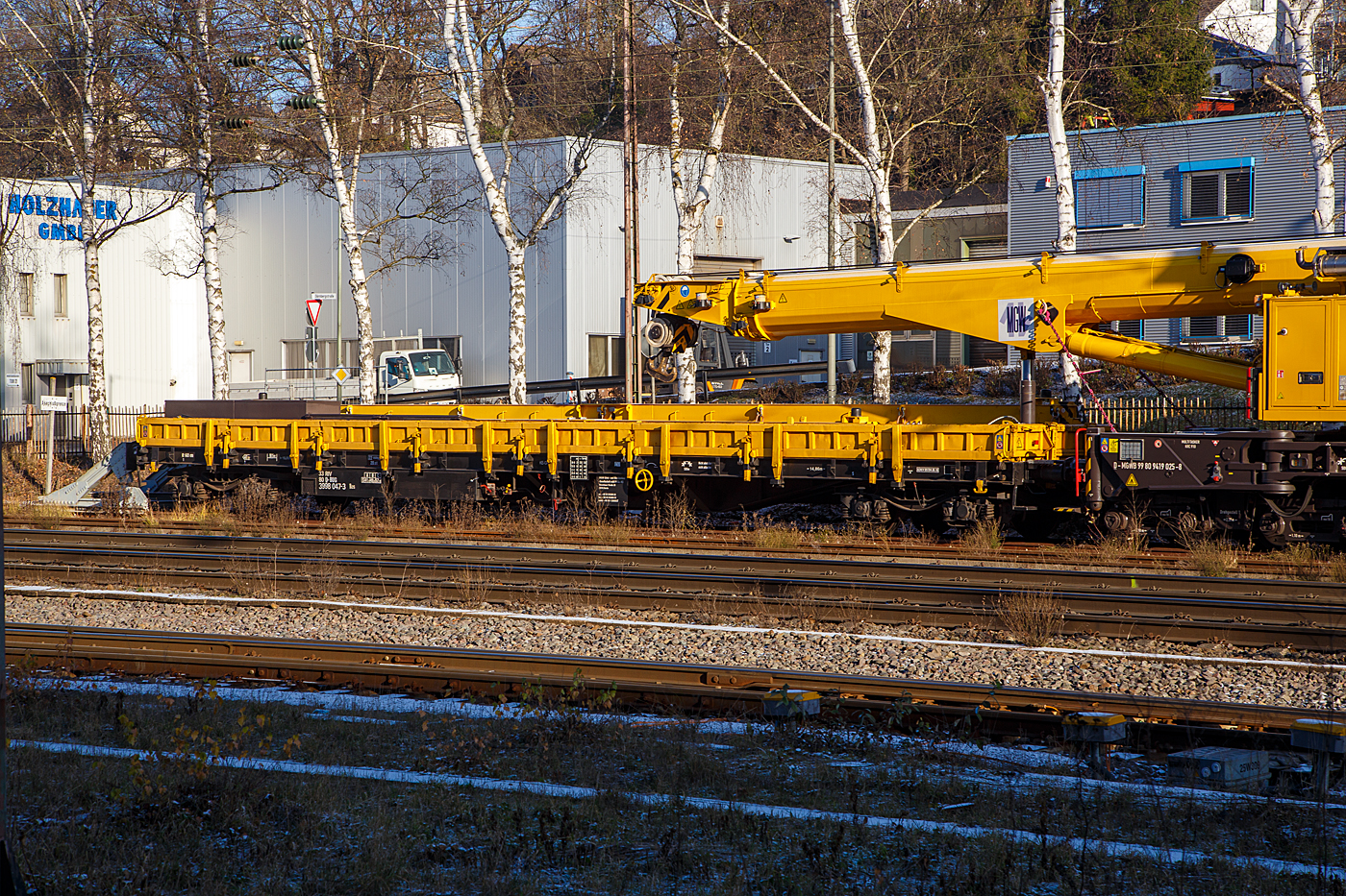 Der 4-achsiger Drehgestell-Flachwagen mit klappbaren Seitenborden sowie Drehrungen, 33 80 3998 047-3 D-BUG, der Gattung Res, der BUG Vermietungsgesellschaft mbH, als Schutzwagen auslegerseitig zum Gleisbauschienenkran - KIROW Multi Tasker KRC 910, Kran 3 der MGW Gleis- und Weichenbau-GmbH & Co.KG (Berlin), Schweres Nebenfahrzeug Nr. D-MGWB 99 80 9419 025-8, am 15.12.2022 abgestellt in Kreuztal.

Gut sieht man wie der Kranausleger mittels Hydraulikzylinder auf den Wagen abgestützt wird, dadurch werden in der Transportstellung die Achslasten vom Kran reduziert. Auf dem Wagen befinden sich die zugehörigen Krantraversen und Anschlagmittel.

TECHNISCHE DATEN: 
Spurweite: 1.435 mm
Länge über Puffer:  19.900 mm
Drehzapfenabstand:  14.860 mm
Achsabstand im Drehgestell: 1.800 mm
Ladebreite: 2.640 mm
Länge der Ladefläche: 18.500 mm
Ladefläche: 49,0 m²
Höchstgeschwindigkeit:  beladen 100 km/h / leer 120 km/h
Eigengewicht:  22.050 kg
Maximale Ladegewicht:  57,9 t (ab Streckenklasse C)
Kleinster bef. Gleisbogenradius: 60 m
Bremse: KE-GP (LL)
Bremssohle: IB 116
Feststellbremse: Ja
Intern. Verwendungsfähigkeit:  RIV