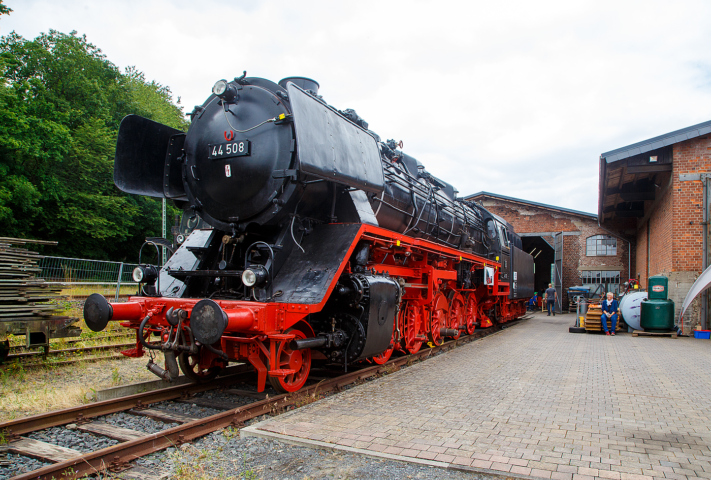 Der „Jumbo“ bzw. die schwere kohlegefeuerte Dreizylinder-G�terzug-Dampflokomotive 44 508, ex DB 044 508-0, am 02.07.2023 ausgestellt beim Lokschuppen vom Erlebnisbahnhof Westerwald der Westerw�lder Eisenbahnfreunde 44 508 e. V. hier war Lokschuppen-/Sommerfest.

Seit der meiner letzten Ablichtung am 05.05.2018 von ihr, siehe http://hellertal.startbilder.de/bild/deutschland~museen-und-ausstellungen~westerwaelder-eisenbahnfreunde-wef-44-508-e-v/610219/man-sieht-es-sehr-deutlich-der.html , hat sich aber viel getan, die Treib- und Kuppelstangen fehlen aber noch. 

Die Lok ist Eigentum vom DB-Museum und eine Leihgabe an die Eisenbahnfreunde, die nach ihr ihren Verein genannt haben. Wie man sieht, gibt es noch viel zu tun bis sie wieder im alten Glanz erstrahlt.

Die Dampflokomotive 44 508 wurde im Jahr 1941 von der Lokomotivfabrik Krauss-Maffei in M�nchen unter der Fabriknummer 16113 gebaut und an die DR geliefert. Nach dem Krieg blieb sie im Westen und wurde so 1949 als 44 508 in den Bestand der Deutsche Bundesbahn aufgenommen, mit der Einf�hrung des EDV-Nummernschemas wurde sie zum 01.01.1968 in 044 508-0 umgezeichnet. Seit Mitte der 1950er Jahre ist sie gekuppelt mit dem 2'2'T34 Tender der ex �BB 44 1561 (Borsig Lokomotiv-Werke GmbH, Hennigsdorf-Berlin, Baujahr 1940, Fabriknummer 15400). Bis zu ihrer Au�erdienststellung im Mai 1977, im BW Gelsenkirchen-Bismarck legte sie eine Strecke von �ber 1.9 Millionen Kilometern zur�ck.

Die Maschine verf�gt �ber ein Drei-Zylinder-Triebwerk, f�nf Antriebsachsen und einen Schlepptender, in dem sie 10 Tonnen Kohle und 34 Kubikmeter Wasser mitf�hren kann. Sie erreicht eine maximale Leistung von 1.910 PS bei einem Dienstgewicht von 160 Tonnen. 

Die 44 508 wurde im Mai 1977 beim Bahnbetriebswerk Gelsenkirchen-Bismarck au�er Dienst gestellt. Die 44 508 ist eine der letzten erhaltenen Dampflokomotiven ihrer Bauart. Sie wurde im Jahr 1987 durch eine Freizeitgruppe des Bahn-Sozialwerkes (BSW) �bernommen. Damit begann die museale Aufarbeitung der Lok, die im Jahre 2002 jedoch unterbrochen wurde, als das Domizil in Siershahn ger�umt werden musste. Der Verein Westerw�lder Eisenbahnfreunde �bernahm diese Dampflokomotive als Leihgabe des DB Museums, auch wenn sie nie im Westerwald eingesetzt war. 

Um das hohe ehrenamtliche Engagement und die damit verbundene immense Zahl von bereits geleisteten Arbeitsstunden zu w�rdigen, soll sie im Erlebnisbahnhof Westerwald weiterhin �u�erlich aufgearbeitet werden und einen Ehrenplatz im Museum erhalten.

Die Lokomotiven der Baureihe 44 der Deutschen Reichsbahn waren schwere, f�nffach gekuppelte G�terzug-Einheitsdampflokomotiven der Gattung G 56.20 mit Drillingstriebwerk. Sie waren vorgesehen f�r die Bef�rderung von G�terz�gen bis 1.200 t auf Mittelgebirgsstrecken und 600 t �ber Steilrampen.

Im Jahr 1926 wurden 10 Prototypen gebaut, denen 1932 zwei weitere folgten. Die Serienfertigung der Baureihe 44 begann erst 1937, nachdem ihr Weiterbau anstelle der Zwei-Zylinder�Lokomotiven der Baureihe 43, die parallel zur 44 entwickelt und gebaut worden war, beschlossen wurde. Die Baureihe 44 wurde dagegen als Drei-Zylinder-Lokomotiven ausgebildet, wobei der dritte Zylinder im Rahmen unter der Rauchkammer angeordnet ist. Die gro�en Leistungsreserven und ihre ausgezeichnete Laufruhe wogen den Nachteil der schwierigen Unterhaltung des im Rahmen schlecht zug�nglichen dritten Triebwerkes mehr als auf. So verwundert es nicht, dass die letzte Dampflokomotive, die bei der Deutschen Bundesbahn in Betrieb war, der Baureihe 44 angeh�rte. Es handelt sich um 44 903 �l, die am 26.10.1977 in Emden au�er Dienst gestellt wurde.

TECHNISCHE DATEN:
Gebaute St�ckzahl: 1989
Bauart  1'E h3
Gattung:  G 56.20
Spurweite:  1435 mm (Normalspur)
L�nge �ber Puffer:  22.620 mm
H�he:  4.550 mm
Fester Radstand:  3.400 mm
Gesamtradstand:  9.650 mm
Dienstgewicht:  169,8 t (mit Tender)
Radsatzfahrmasse:  19,8 t
H�chstgeschwindigkeit: 80 km/h (r�ckw�rts nur 50 km/h)
Leistung:  1.910 PS (1.405 kW) bei Lok mit �lfeuerung 2.100 PS
Treibraddurchmesser:  1.400 mm
Laufraddurchmesser vorn:  8.50 mm
Zylinderanzahl:  3
Zylinderdurchmesser:  550 mm
Kolbenhub:  660 mm
Kessel�berdruck:  16 bar
Rostfl�che:  4,55 m�
�berhitzerfl�che:  100,00 m�
Verdampfungsheizfl�che:  237,67 m�
Bremse:  selbstt�tig wirkende Einkammer-Druckluftbremse Bauart Knorr
Steuerung:  Bauart Heusinger
Tender: 2´2´T34
Kohlenvorrat:  10 t
Wasservorrat: 34 m�
