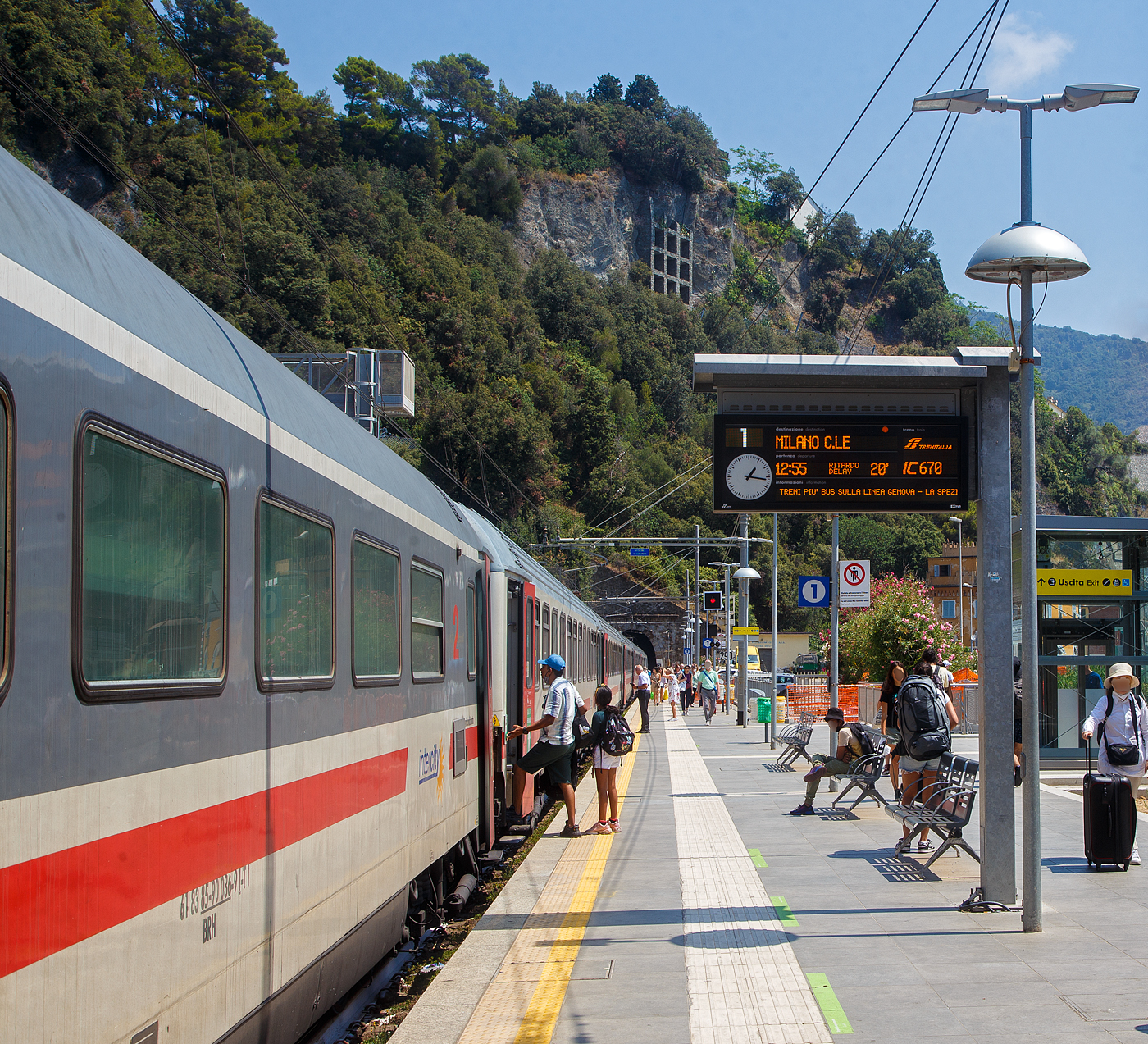 Der Bahnhof Monterosso Cinque Terre (komplette Bezeichnung der Gemeide Monterosso al Mare) an der Italienischen Riviera. Von den Cinque Terre Bahnhöfen hat Monterosso die längsten Bahnsteige unter freiem Himmel, so halten hier auch Intercity-Züge. 

Das Fischerdorf Monterosso al Mare ist das nördlichste Dorf und mit rund 1700 Einwohnern der größte Ort der Cinque Terre an der Italienischen Riviera. Monterosso erstreckt sich über rund 1,5 Kilometer und ist zweigeteilt, die kleine Altstadt ist vom neueren Viertel Fegina durch einen ins Meer ragenden Felsen getrennt, auf dem sich der markante Wachtturm Torre Aurora aus dem 16. Jahrhundert erhebt. Durch den Felsen führt ein rund 100 m langer Fußgängertunnel.

Hier hält am 22.07.2022 gerade, im Sandwich zweier E.414 (ehemalige Triebköpfe E.404 A der ersten ETR 500 – Monotensione), der Trenitalia InterCity IC 670 (Livorno – Pisa - La Spezia - Monterosso - Genova - Milano Centrale), im Cinque Terre Bahnhof Monterosso.