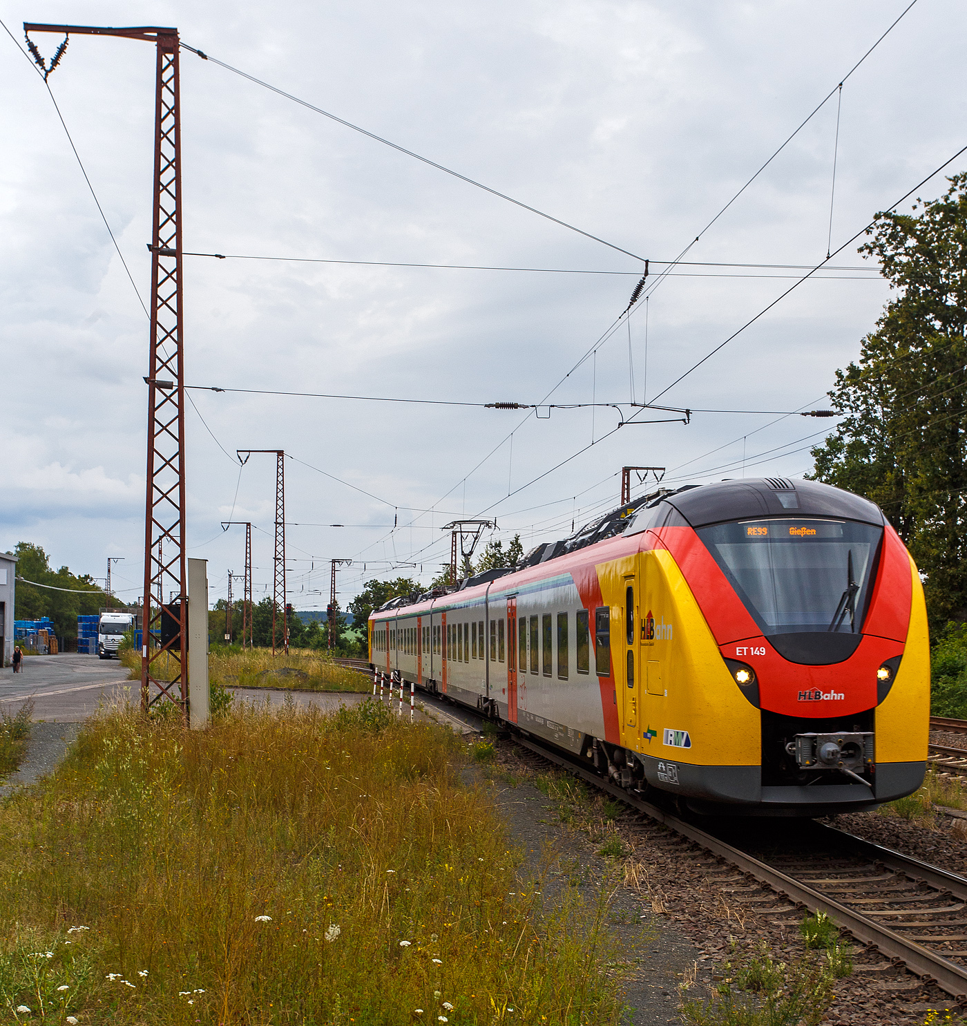 Der ET 149 (94 80 1440 149-1 D-HEB / 94 80 1441 149-0 D-HEB / 94 80 1441 649-9 D-HEB / 94 80 1440 649-0 D-HEB) ein vierteiliger Niederflur-Elektrotriebwagen vom Typ Alstom Coradia Continental  2  (XCC MHX) der HLB (Hessische Landesbahn), erreicht am 01 August 2024 als RE 99 „Main-Sieg-Express“ (Siegen – Gießen) den Bahnhof Rudersdorf (Kreis Siegen). 

Der vierteilige Niederflur-Elektrotriebwagen wurde 2023 von ALSTOM Transport Deutschland GmbH (vormals LHB - Linke-Hofmann-Busch GmbH) in Salzgitter-Watenstedt unter der Fabriknummer D041544-08 gebaut.

Am 27. Mai 2021erhielt Alstom einen Auftrag zur Lieferung von 32 Coradia Continental Elektrotriebzügen von der Hessischen Landesbahn GmbH (HLB) erhalten. Die Bestellung teilt sich auf in insgesamt zwölf 4-Teiler sowie zwanzig 5-Teiler und hat einen Gesamtwert von rund 200 Mio. Euro.

Alstom CORADIA Continental 2 ist ein hochmoderner Elektrotriebzug und die ideale Lösung für den Regionalverkehr im mittleren Hessen. Er ist zuverlässig, schnell und leise und bietet für die Passagiere höchsten Fahrkomfort, inklusive reichlich Platz für Fahrräder und Gepäck. Der Coradia Continental erreicht Betriebsgeschwindigkeiten von bis zu 160 km/h und bietet als vier- und fünfteilige Einheiten 206 bzw. 282 Sitzplätze. Verschiedene Mehrzweckbereiche halten ausreichend Platz für Rollstühle, Fahrräder und Kinderwagen bereit. Die Antriebsausrüstung der Züge ist auf dem Dach angeordnet, sodass der Innenraum großzügig gestaltet ist, u.a. mit einem breiten und stufenfreien Gang für besseren Fahrgastfluss. Insbesondere wird durch eine angepasste Einstiegshöhe in Verbindung mit zusätzlichen Schiebetritten ein sehr komfortabler Zugang in das Fahrzeug gewährleistet. Der Coradia Continental ist im gesamten Zug mit WLAN, Videoüberwachung sowie Laptopanschlüssen und einem Echtzeit-Fahrgastinformationssystem ausgestattet, das Verbindungsdaten anzeigt.

Verbesserte Barrierefreiheit:
Mit der reduzierten Einstiegshöhe von 60 cm können mobilitätseingeschränkte Fahrgäste auch an niedrigen Bahnsteigen barrierefrei ein- und aussteigen. Alle Fahrzeuge sind mit einem Schiebetritt ausgestattet. Dieser dient, je nach Bahnsteighöhe, als Spaltüberbrückung zum Bahnsteig oder Trittstufe. Auch Fahrgäste mit Kinderwagen, Fahrrädern oder Gepäck profitieren vom barrierefreien Zugang. Große Piktogramme weisen Fahrgästen leicht ersichtlich auf die Rollstuhl- und Fahrradbereiche hin.

Alstoms Coradia Reihe von modularen Zügen profitiert von mehr als 30 Jahren kontinuierlicher Weiterentwicklung und bewährten technischen Lösungen. Bisher wurden mehr als 3.300 Coradia Züge verkauft und rund 2.900 verkehren zurzeit in Dänemark, Frankreich, Deutschland, Italien, Luxemburg, den Niederlanden, Schweden und Kanada

Diese vierteiligen Triebzüge setzen sich auch den folgenden Wagenbaureihen zusammen1440.1 – 1441.1 – 1441.6 – 1440.6 uns sind so 73.300 mm und haben 8 Fahrmotoren. Die Triebzüge haben konventionelle Enddrehgestelle und Jakobs-Drehgestelle zwischen den Mittelwagen

TECHNISCHE DATEN:
Hersteller: Alstom Transport Deutschland GmbH (Salzgitter-Watenstedt)
Baureihe: 1440.1
Art: vierteiliger Niederflur-Elektrotriebwagen
Fahrzeugbestand der HLB :12 (XCC MHX) / 22 (XCC SHU)
Spurweite: 1.435 mm
Achsfolge: Bo’(Bo’)(2’)(Bo’)Bo’ in Klammern Jakobs-Drehgestelle
Länge über Kupplung: 73.300 mm
Drehzapfenabstände: 15.550 mm / 2 x 16.400 mm / 15.550 mm
Achsabstand in den Enddrehgestellen: 2.440 mm
Achsabstand in den Jakobsdrehgestellen: 2.700 mm
Treib- und Laufraddurchmesser: 850 mm (neu) / 780 mm (abgenutzt)
Breite: 2.920 mm
Maximale Höhe (über SO): 4.280 mm
Einstieghöhe (über SO): ca. 600 mm
Eigengewicht: ca. 145 t
Minimaler befahrbarer Gleisbogen Werkstatt/Betrieb: 100/150 m
Stromsystem: 15 kV / 16,7 Hz
Höchstgeschwindigkeit: 160 km/h
Dauerleistung: 2.000 kW
Max. Stundenleistung: 2.880 kW
Fahrgastsitzplätze: 206 (davon 14 in der 1. Klasse)
Niederfluranteil: ca. 89 %
Fahrgasteinstiegstüren je Längsseite: 4
Bremse: KB C-el-pn-R-A-E-Mg (D)
