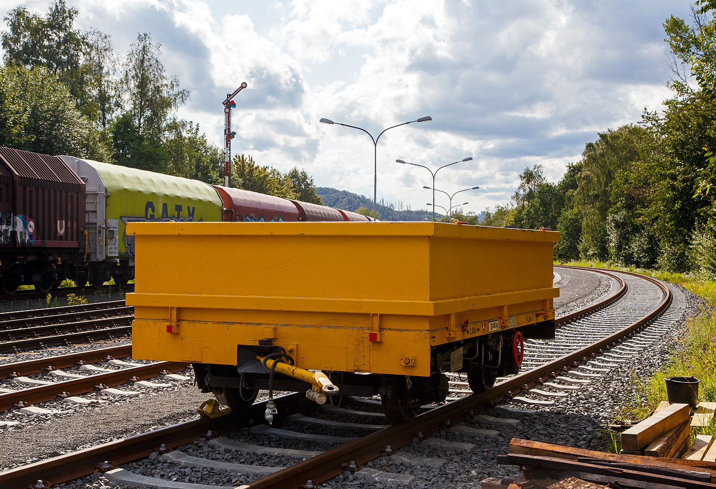 Der Gleiskraftwagenanh�nger GKW-A, Kleinwagen-Nr. D-BMSS 99 80 9750 489-3 der BMS Schlage (Lieske) ist am 26.08.2023 in Herdorf auf dem Rbf der KSW, Betriebsst�tte FGE -Freien Grunder Eisenbahn, abgestellt. 

Der Kleinwagenanh�nger  34.1 Typ GKW-A -H 25 (der BA 341) wurde 1962 vom RAW Sch�nweide gebaut. Von der f�nfstelligen Fabriknummer kann ich leider nur die letzten drei Ziffern (??392) genau erkennen. Bei diesem Anh�nger wurden die Seiten- und Stirnwandklappen gegen einen aufgesteckten Aufsatzrahmen getauscht.

Wie auch die Deutsche Bundesbahn (DB) setzte die Deutsche Reichsbahn (DR) in der DDR Kleinwagen mit eigenem Antrieb und passende Anh�nger im Streckenunterhalt ein. W�hrend die Bundesbahn die Abk�rzung Klv und Kla (Kleinwagen mit Verbrennungsmotor bzw. -Anh�nger) verwendete, k�rzte die DR mit den Buchstaben GKW f�r Gleiskraftwagen bzw. GKW-A f�r Gleiskraftwagen-Anh�nger ab. 

TECHNISCHE DATEN:
Spurweite: 1.435 mm (Normalspur)
L�nge �ber Kupplung: 4.000 mm
Achsabstand: 2.000 mm
Laufraddurchmesser: 560 mm
Eigengewicht: 3.400 kg 
Nutzlast: 8 t (urspr�nglich lt. Fabrikschild 9.500 kg) 
Zul. Geschwindigkeit (Hg): 60 km/h
Handbremse: Ja
