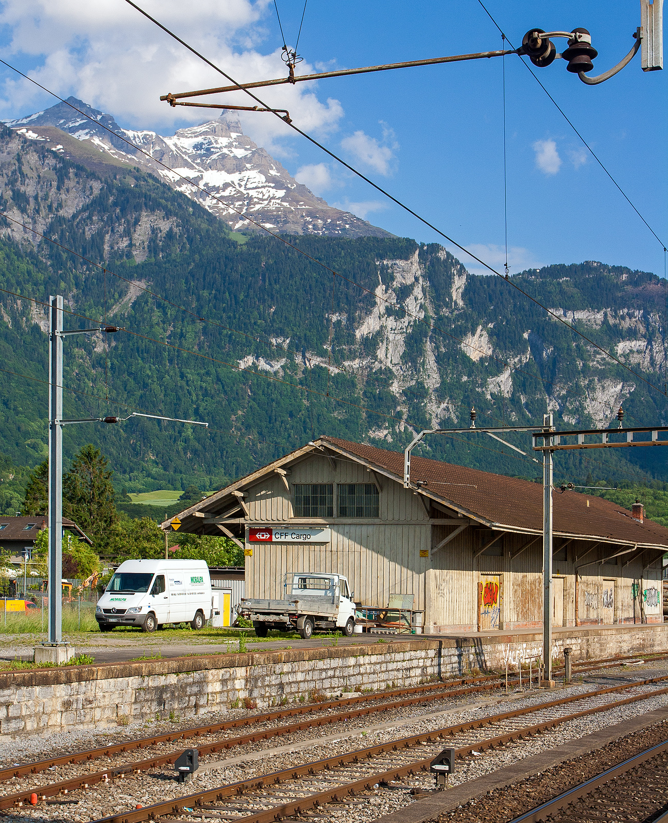 Der G�terschuppen von Bex, am 28 Mai 2012, fr�her gingen die Gleise der BVB hinter der Rampe bis an den G�terschuppen zur �bergabe an die SBB.

Bild aus dem Zug heraus.
