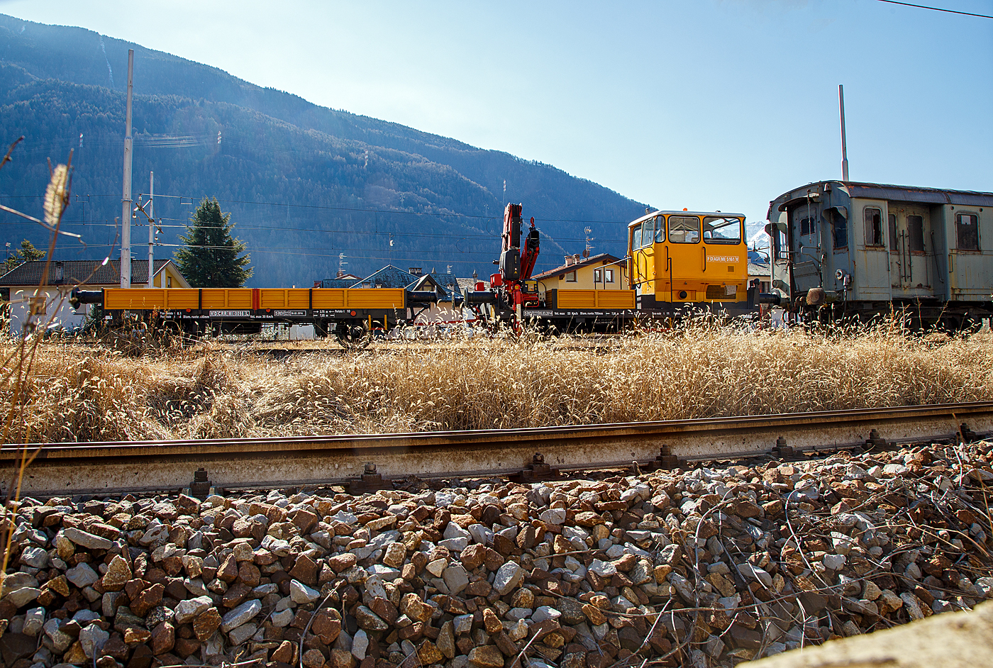 Der Italienische Rottenkraftwagen mit Kran/ Motocarrello di servizio con gru a bracci, F D AGR MI 5161 V (ähnlich einem Klv 53 der DB) mit dem zweiachsigem Gleiskraftwagenanhänger WD CRR MI 0098 L abgestellt am 19 Februar 2017 in Tirano, leider hier im Gegenlicht. Rechts der Steuerwagen FS pBz 623 327 zu den Triebwagen der Baureihen E.623 (Automotrice elettrica E.623 - Rimorchi pBz 623).

Der Klv 53 (Kleinwagen mit Verbrennungsmotor 53) zählte bei der DB ursprünglich zu den meistgebauten Arbeitszugfahrzeugen. Im Rahmen von Modernisierungs- und Umstrukturierungsmaßnahmen wurden und werden viele der inzwischen etwas angejahrten Fahrzeuge an private Gleis- und Oberleitungs-Baufirmen sowie Privatbahnen im In- und Ausland verkauft und sind dort nach einer meist gründlichen Aufarbeitung und Detail-Umbauten nach wie vor im Einsatz. Dieses Fahrzeug hat einen Kran vom Italienischen Hersteller FASSI (Typ Fassi F 150), bei den DB Klv 53 wurden Ladekrane von Atlas oder Meiller verwendet. Zudem hat das Italienische Fahrzeug wie auch der Wagen hier (schwere) Hülsenpuffer, so sind diese Fahrzeuge auch etwas länger.

TECHNISCHE DATEN vom Klv: 
Spurweite: 1.435 mm (Normalspur)
Achsformel: B
Länge über Puffer: 7.060 mm
Achsabstand: 3.750 mm
Treibraddurchmesser: 700 mm (neu)
Höchstgeschwindigkeit : 55 km/h
Eigengewicht: 11 t 
Nutzlast: 2 t

TECHNISCHE DATEN vom Wagen:
Länge über Puffer: 7.050 mm 
Achsabstand: 3.750 mm 
Laufraddurchmesser: 700 mm (neu)
Höchstgeschwindigkeit : 30 km/h
Eigengewicht: 4,0 t
Nutzlast: 10 t
