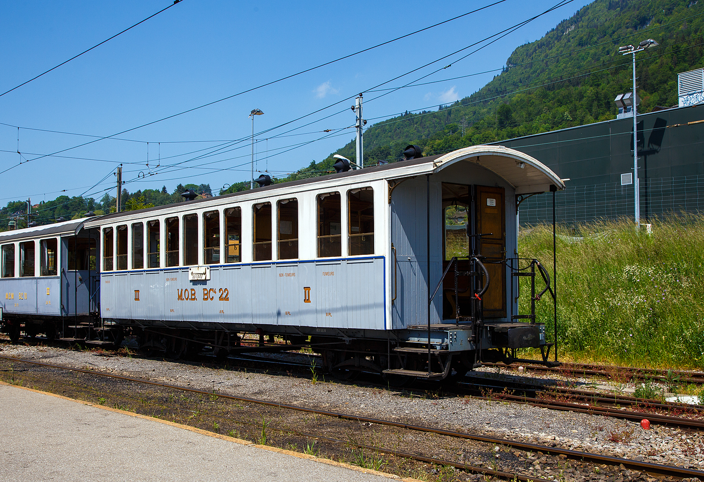Der meterspurige vierachsige 2./3. Klasse (Raucher / Nichtraucher) Drehgestell-Abteil-Plattformwagen MOB BC⁴ 22 (ex MOB C⁴ 45) der Museumsbahn Blonay-Chamby am 27 Mai 2023 im Bahnhof Blonay.

Der Wagen wurde von der Schweizerische Industrie-Gesellschaft Neuhausen (SIG) 1902 gebaut und als MOB BC⁴ 22 an die Montreux-Berner Oberland-Bahn (MOB) geliefert, 1912 erfolgte die Umzeichnung zum C⁴ 22 45. Die auf der linken Seite erkennbaren zwei Doppelfenster mit größerem Abstand erinnern noch an die früheren 2.-Klasse-Abteile, die sich dort befanden. Im Jahr 1956, mit dem Wegfall der 3. Klasse, wurde der Wagen zum B 45. Im Jahr 1971 kam der Wagen als Geschenk an die Museumsbahn Blonay–Chamby und wurde wieder in den alten Zustand versetzt. Der 9,6 Tonnen schwere, 11,5 m lange Wagen bietet 48 Fahrgästen in der 3. Klasse Platz.

Das Bild zeigt den Zustand des Wagens von 2012, aktuell fährt der Wagen bei der Museumsbahn Blonay–Chamby wieder als MOB BC4 22.

TECHNISCHE DATEN:
Spurweite: 1.000 mm (Meterspur)
Achsanzahl: 4 (in 2 Drehgestellen)
Länge über Puffer: 11.500 mm
Drehzapfenabstand: 6.500 mm
Achsabstand im Drehgestell: 1.200 mm
Eigengewicht: 9,6 t
Höchstgeschwindigkeit: 55 km/h
Sitzplätze: 16 in der 2. Klasse und 32 in der 3. Klasse
