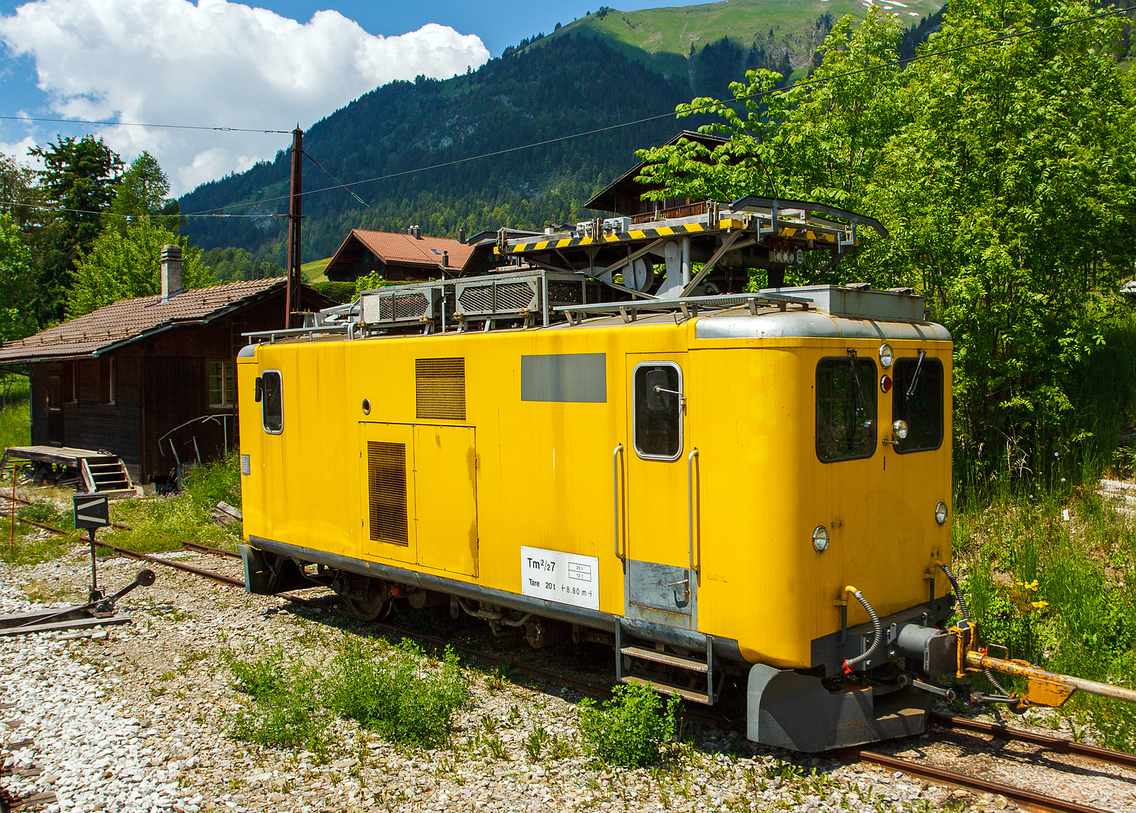 Der MOB Fahrleitungs-Turmtriebwagen Tm 2/2 - 7 (ex RhB Xm 2/2 9914) abgestellt am 28.05.2012 in Château d'Oex, aufgenommen aus fahrendem Zug. 

Der Fahrleitungs-Turmtriebwagen wurde 1903 als RhB F 511 gebaut, 1911 erfolgte die Umzeichung in RhB F 4011, 1950 erfolgte dann der Umbau zum Fahrleitung Turmtriebwagen RhB Xm 2/2 9914.

Der Triebwagen (bzw. Traktor) besitzt beidseitig eine Kabine für stehende Bedienung, eine Höhenverstellbare Arbeitsbühne 360° drehbar und einen Saurer BXD 4 Zylinder-Dieselmotor mit 110 kW Leistung. 

Die MOB (Montreux–Berner Oberland-Bahn) kaufte ihn dann 2007 von der RhB, 2009 erfolgte die Inbetriebnahme mit neuer Bezeichnung Tm 2/2 7. Er bleibt für den SE (Sécurité et Energie) in Château d'Oex stationiert. Wegen fehlender Magnetschienenbremse ist er nur für den Streckenabschnitt Montbovon - Lenk zugelassen.

TECHNISCHE DATEN:
Anzahl Fahrzeuge: 1
Spurweite: 1.000 mm
Achsformel: B
Länge über Puffer: 8.800 mm
Achsabstand: 4.400 mm
Treibraddurchmesser: 850 mm (neu)
Breite: 2.580 mm
Höhe: 4.030 mm
Höchstgeschwindigkeit: 55 km/h (60 km/h Schleppfahrt)
Dieselmotor: 4 Zylinder Saurer BXD 
Leistung: 110 kW
Dienstgewicht: 20.00 t
Max. Zuladung: 2 t
Ladefläche: 2 m²