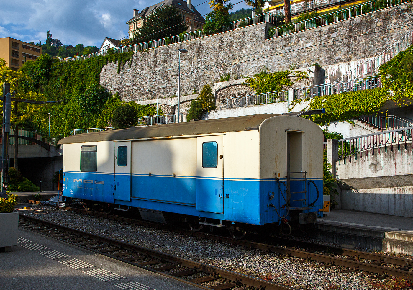 Der MOB vierachsige 2. Klasse Personenwagen mit Gep�ckabteil MOB BD 33 (bzw. Gep�ckwagen mit Personenabteil) abgestellt am 26.05.2023 beim Bahnhof Montreux. Der Wagen ist im alten „cr�me – blau“ und tr�gt nach die Anschrift „MOB - Golden Panoramic Line“. 

Der Wagen entstand 1999 durch Umbau aus dem PTT Postwagen D 33, ex PTT Z 33, und geht 1999 in den Besitz der MOB (Montreux Oberland Bernois / Montreux-Berner Oberland-Bahn), zuvor war er Eigentum der PTT (Schweizerische Post). Die Inneneinrichtung des Wagens wurde entfernt, im ehemaligen B�roteil wurde ein Personenabteil mit zwei gro�en Fenstern eingebaut, es hat f�nf bequeme Klappsitze oder Platz f�r bis zu sechs Rollst�hle. Das Personenabteil ist nur f�r Behinderte und ihre Begleiter zug�nglich. Einsatz f�r Rollstuhltransporte, als Velowagen oder bei Ausfall eines BD 204 - 206. Ab 2010 kam er als K�chenwagen im  Meurtre-Myst�re   zum Einsatz.

Der Ursprung des Wagens geht ist Jahr 1924 zur�ck, f�r den Bau des PTT Z 33 wurde das Unter-/Fahrgestellt des ehem. Von SWS gebauten AB⁴ 85 (ab 1956 A⁴ 85) verwendet.

TECHNISCHE DATEN:
Hersteller: MOB / FFA / SIG
Spurweite: 1.000 mm (Meterspur)
Achsanzahl: 4 (in 2 Drehgestellen)
L�nge �ber Puffer: 13.100 mm 
H�he: 3.380mm
Breite: 2.680 mm
Drehzapfenanstand: 7.800 mm
Achsabstand im Drehgestell: 1.800 mm
Drehgestell Typ: SIG- Torsionsstab
Laufraddurchmesser: 750 mm (neu)
Eigengewicht: 17,2 t (urspr�nglich 14 t)
H�chstgeschwindigkeit: 80 km/h
Sitzpl�tze: 5 (in der 2. Klasse) 
Ladegewicht: 2,8 t (urspr�nglich 7,5 t)

Quellen: x-rail.ch
