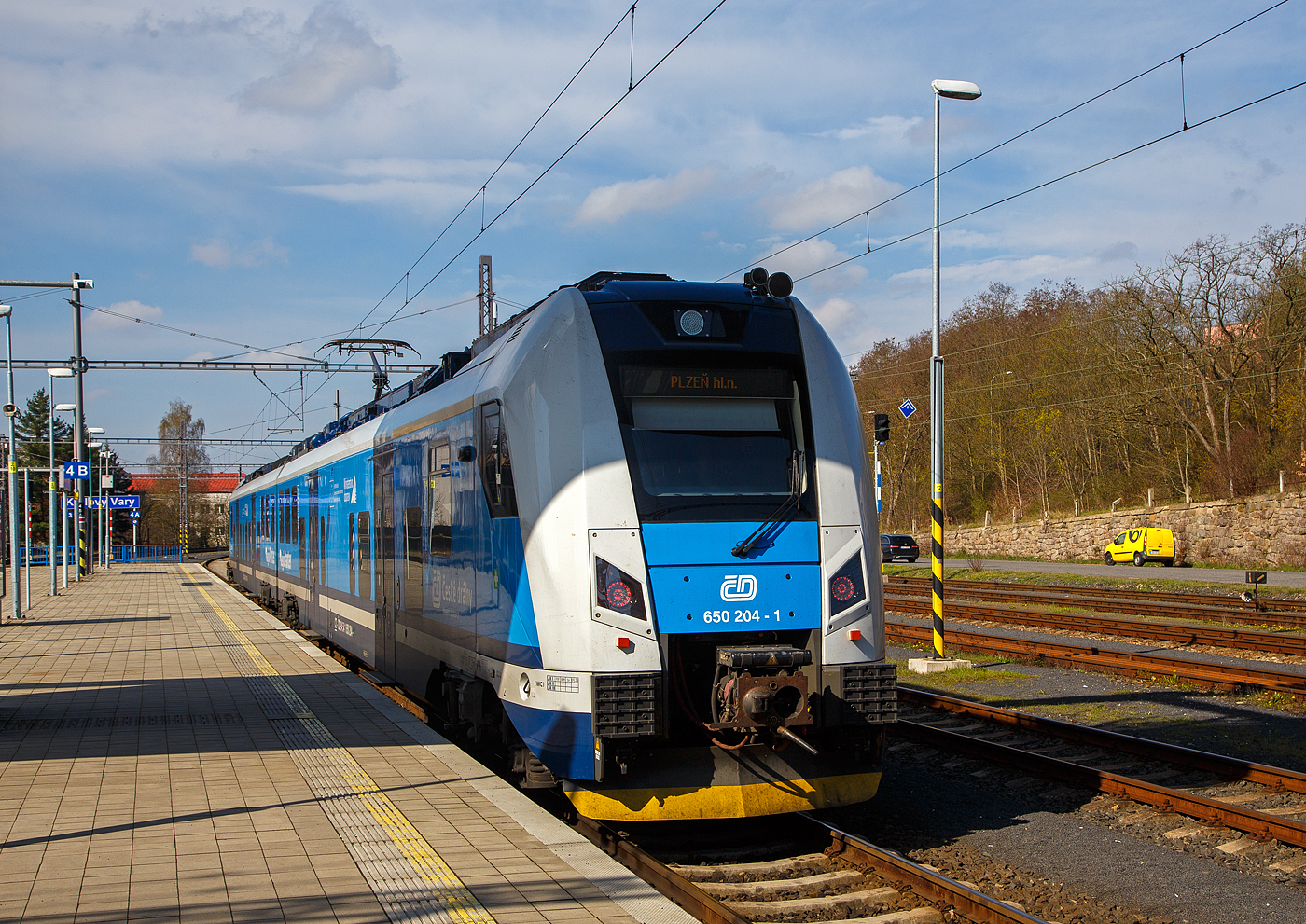 Der RegioPanter 651 204-0 / 650 204- 1 (CZ-ČD 94 54 1 651 204-0 / CZ-ČD 94 54 1 650 204-1), ein zweiteiliger Zweisystem-Elektrotriebzug (3 kV DC und 25 kV, 50 Hz~) vom Typ Škoda15 Ev, der České dráhy (ČD) / Plzeňský Kraj (deutsch Pilsner Region), steht am 21 April 2023 im Bahnhof Karlovy Vary (Karlsbad, oberer Bahnhof bzw. Karlsbad Hbf), als Sp (Spěšný vlak / Eilzug) nach Pilsen (Plzeň) via Cheb (Eger) zur Abfahrt bereit. 

Der zweiteiliger zweisystemfähiger (3 kV DC und 25 kV, 50 Hz~) Elektrotriebzug vom Typ Škoda15Ev/HV14 wurde 2021 von Škoda Vagonka a.s. in Ostrava (ex ČKD Vagónka Studénka) gebaut.

Die einstöckigen Elektrotriebzüge RegioPanter stellen eine völlig neue Generation von modernen Niederflur-Fahrzeugen dar. Sie werden mit einem Stromsystem (3 kV DC) und mit zwei Stromsystemen (3 kV DC und 25 kV / 50 Hz AC) bei der wie die hier gezeigten BR 650 / 651 angeboten. Die ČD hat zwei- und dreiteilige Einheiten bestellt, laut Hersteller sind bis zu sechsteilige Kompositionen möglich. Bis zu vier Wagenzüge sind kuppelbar. Die BR 650.2 / 651.2 werden als Typ ¦koda 15 Ev und sind gegenüber der BR 650.0 / 651.0 (¦koda 7 Ev) modifiziert. Beide Wagenteile sind jeweils mit einem Triebdrehgestell mit zwei Asynchronmotoren und einem üblichen Laufdrehgestell ausgestattet. Im Vergleich zu den vorhanden Zwei-Wagen-Zügen verbraucht der Zug RegioPanter bis um eine Hälfte weniger Strom, und zwar auch dank des Systems der Energierückgewinnung, die beim Bremsen entsteht. Die einstöckige regionale Einheit ist als ein völlig durchgängiger Zug konzipiert, d.h. ohne Innenzwischenwände und Türen. Offen ist auch der Übergang zwischen den Wagen. Die meiste elektrische Ausrüstung befindet sich auf dem Dach, wodurch sich der Fahrgastraum erheblich erweitert. Die Drehstrom-Traktionsmotoren vom Typ ¦koda ML 3942 K/4 besitzen eine Leistung von je 340 kW.

TECHNISCHE DATEN:
Spurweite: 1.435 mm
Achsformel: Bo‘2‘+2‘Bo‘
Länge über Kupplung: 52.900 mm
Breite: 2.820 mm
Höhe: 4.260 mm
Drehzapfenabstand: 19.000 mm
Achsabstand im Drehgestell: 2.400 mm
Raddurchmesser: 850 (neu) / 770 mm (abgenutzt)
Dauerleistung: 1.360 kW (4 x 340 kW)
Höchstgeschwindigkeit: 160 km/h
May. Beschleunigung: 1,1 m/s²
Stundenzugkraft: 131 kN
Kleinster befahrbarer Gleisbogen: 125 m
Stromsystem: 3 kV DC und 25 kV / 50 Hz AC
Leergewicht: 102,8 t
Anzahl der Sitzplätze: 140, davon 8 in der 1. Klasse
Anzahl der Stehplätze: 183
Plätze für Fahrräder/Kinderwagen: 9 / 4