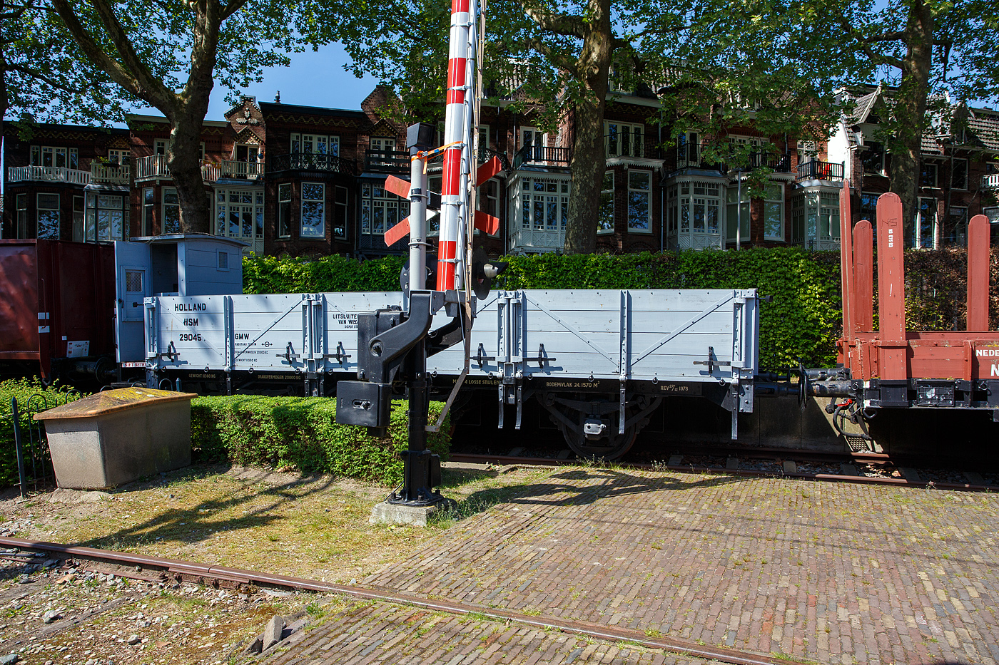 Der Schwellenwagen HSM 29045 GMW, ein dreiachsiger offener Güterwagen mit Bremserhaus der ehemaligen HSM - Hollandsche Spoorweg Maatschappij (Holländische Eisenbahn-Gesellschaft), teils auch als HIJSM - Hollandse IJzeren Spoorweg-Maatschappij geführt, am 29 April 2025 im Het Spoorwegmuseum (bis 2005 NSM - Nederlands Spoorwegmuseum / Niederländischen Eisenbahnmuseum) in Utrecht im Bahnhof Maliebaan.

Der Wagen vom Typ GMW der Serie 29041 – 29050 wurde 1911 durch die HIJSM Centrale Werkplaats in Haarlem (Zentralwerkstatt der HSM) gebaut. Bedingt durch den Ersten Weltkrieg wurde 1917 eine Zweckgemeinschaft der unabhängigen Eisenbahngesellschaften HSM und SS (Maatschappij tot Exploitatie van Staatsspoorwegen) gegründet. Die beiden Gesellschaften errichteten einen gemeinsamen Bahnbetrieb, blieben aber rechtlich unabhängig. Dies änderte sich 1938, als HIJSM und SS vollständig fusionierten und in der AG NS (Nederlandse Spoorwegen, früher Nederlandsche Spoorwegen geschrieben) aufgingen. Das Rollmaterial wurde bereits 1921 zusammengelegt, so wurden der Wagen zum NS 174545 nummeriert. Die Restaurierung des Wagens wurde zum Teil durch einen Beitrag der Freunde des Eisenbahnmuseums ermöglicht.

Sein Name hat nichts mit einer möglicherweise schwierigen Operation zu tun. HSM nutzt diesen offenen Güterwagen hauptsächlich zum Transport von Materialien für den Bau und die Instandhaltung der Eisenbahnstrecken. Sie transportieren unter anderem ... Schwellen. Dafür verfügen sie über einen breiteren Wagenkörper. Auch für den Transport von Schüttgut, wie beispielsweise Sand, eignet sich der Schwellenwagen sehr gut. Die offenen Wagen lassen sich durch Aufklappen der dreiteiligen Seitenwände bequem beladen und entleeren. Auffälliges Merkmal dieses Wagens ist das Bremserhaus. Jeder Wagen verfügt über einen eigenen Bremser, der den Wagen auf Zeichen des Lokführers, entsprechend bremst bzw. zum Stehen bringt. Nach Einführung der durchgehenden Westinghouse-Bremse sind die Bremserhäuser nicht mehr erforderlich. Jeder Wagen verfügt dann über eine Bremse, die mit der Lokomotive gekoppelt ist. Dadurch kann der Lokführer den Zug vollständig zum Stehen bringen.

TECHNISCHE DATEN:
Spurweite: 1.435 mm (Normalspur)
Anzahl der Achsen: 3
Länge über Puffer: 10.445 mm
Achsabstand: 5.000 mm (2 x 2.500 mm)
Länge der Ladefläche: 13.000 mm
Ladefläche: 24,157 m²
Leergewicht: 11.360 kg
Max. Zuladung: 20.000 kg
Höchstgeschwindigkeit: 80 km/h
