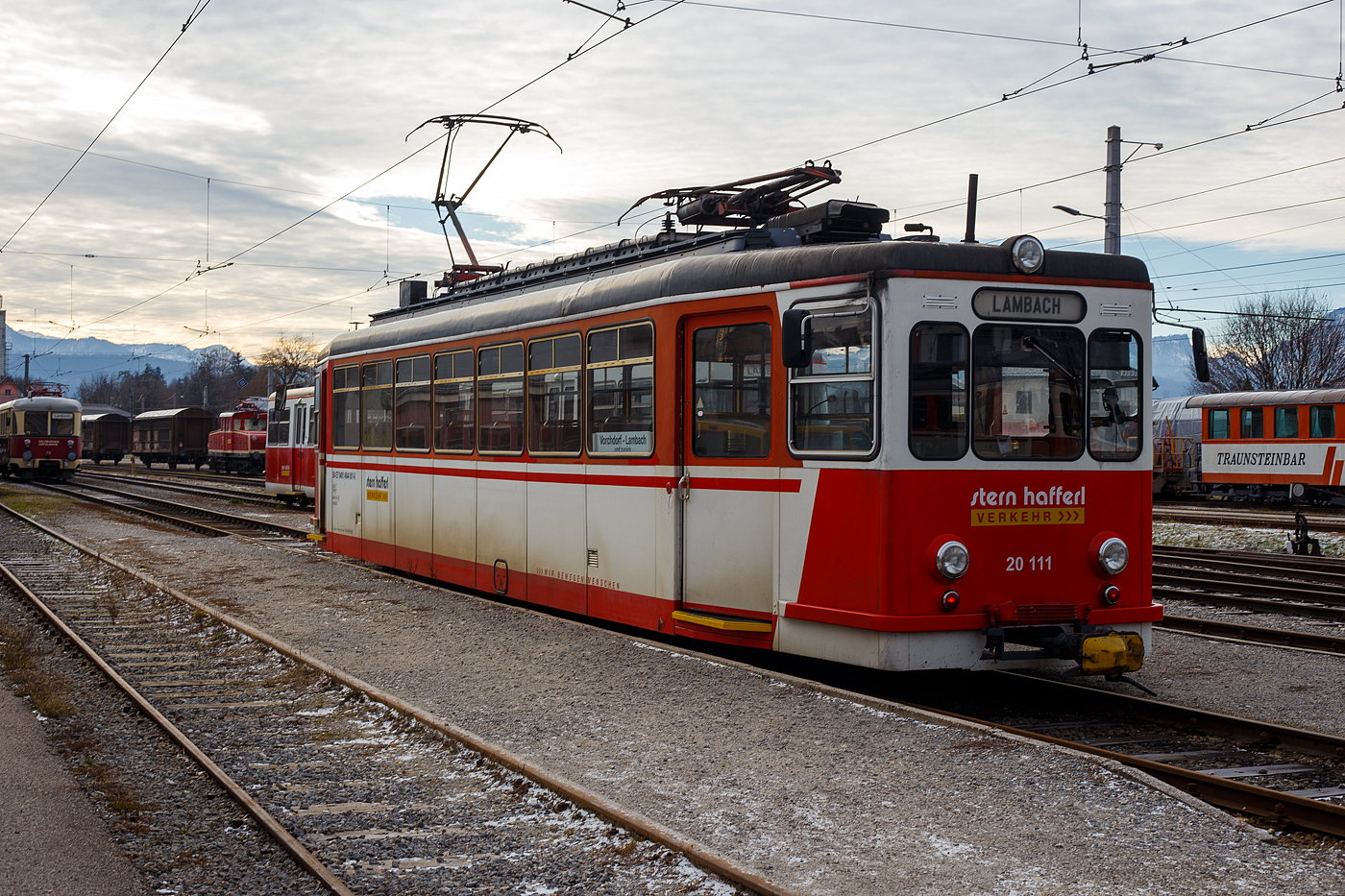 Der Triebwagen ET 20 111 (B4 ET 9481 4944 001-8) der Stern & Hafferl Verkehrsgesellschaft m.b.H. (StH), ex Extertalbahn ET 5 (der vbe - Verkehrsbetriebe Extertal GmbH), steht am 14 Januar 2025 im Bahnhof Bahnhof Vorchdorf-Eggenberg,.als Linie 160 „Vorchdorferbahn“, zur Abfahrt nach Lambach bereit.

Der Elektrotriebwagen wurde 1953 von Westwaggon (Vereinigte Westdeutsche Waggonfabriken) für die Extertalbahn AG (heute vbe - Verkehrsbetriebe Extertal GmbH) gebaut (die Elektrik ist von AEG), wo er bis zu dessen Aufgabe der Verkehrsleistung Ende 1969 im Einsatz war. Danach wurden er wie 2 weitere ET an das österreichische Verkehrsunternehmen Stern & Hafferl verkauft. Hier sind sie noch heute im alltäglichen Planverkehr im Einsatz. Bei der vbe fuhren die ET unter 1.500 V Gleichstrom hier bei der Vorchdorferbahn fahren sie unter 750 V Gleichstrom. 

Die Baureihe Extertalbahn ET 4 bis 6 sind vierachsige normalspurige Elektrotriebwagen der Extertalbahn für deren Strecke von Rinteln nach Barntrup (Deutschland). Diese wurden 1953 und 1956 beschafft und waren für den Personenverkehr ohne Beiwagen bestimmt. Um den Personenverkehr attraktiver zu gestalten, bestellte die Extertalbahn AG zwei Triebwagen, die 1953 von Westwaggon als ET 4–5 ausgeliefert wurden. Mit den Fahrzeugen konnte der Personenverkehr nach Aufgabe des Beiwagenbetriebes wesentlich beschleunigt werden, sodass 1956 ein dritter Triebwagen von der Waggonfabrik Rastatt als ET 6 geliefert wurde. Vorteile war neben der höheren Geschwindigkeit das größere Fassungsvermögen der Fahrzeuge. Mit ihnen wurde außerdem der Schaffnerbetrieb aufgegeben.

Mit den drei Zweirichtungswagen wurde der gesamte Personenverkehr bis zu dessen Aufgabe Ende 1969 durchgeführt. Danach wurden sie an das österreichische Verkehrsunternehmen Stern & Hafferl verkauft und sind nach wie vor dort im alltäglichen Planverkehr anzutreffen.

Die Fahrzeuge haben einen kantigen Wagenkasten. An den leicht verjüngten Fahrzeugenden befinden sich vor den Einstiegen die Führerpulte. Der hintere Einstiegsraum kann als Traglastenabteil verwendet werden. Zwischen den Einstiegen befindet sich das durch eine Abteilwand und Schiebetür abgetrennte Fahrgastabteil mit Vis-à-vis-Bestuhlung und Mittelgang.

Die Fahrzeuge erhielten eine Beleuchtung mit Dreilicht-Spitzensignal. Obwohl sie technisch straßenbahnähnlich sind, sind sie nach dem Umgrenzungsprofil E der Eisenbahn aufgebaut. Es werden alle vier Achsen über ein Stirnradgetriebe in Reihen- bzw. Parallelschaltung angetrieben. Die Steuerung erfolgt über ein Gleichstromnockenschaltwerk. Die Druckluft für die Druckluftbremse und die Türsteuerung wird von einem doppeltwirkenden Kompressor erzeugt.

TECHNISCHE DATEN:
Spurweite: 1.435 mm (Normalspur)
Achsformel: Bo' Bo'
Länge: 16.300 mm
Höhe: 3.190 mm (ohne SA)
Breite: 2.800 mm
Drehzapfenabstand: 7.900 mm
Achsabstand im Drehgestell: 1.800 mm
Dienstgewicht: 26.500 kg
Höchstgeschwindigkeit: 70 km/h
Dauerleistung: 4 × 75 kW
Raddurchmesser: 770 mm (neu)
Stromsystem: 750 V DC (=) / früher 1.500 V DC
Stromübertragung: Oberleitung
Anzahl der Fahrmotoren: 4
Bremse: Druckluftbremse, el. Widerstandsbremse, Spindelhandbremse
Sitzplätze: 56/4

Die Lokalbahn Lambach–Vorchdorf-Eggenberg, auch Vorchdorferbahn genannt, ist eine normalspurige Lokalbahn in Oberösterreich. Die Strecke verläuft vom Bahnhof Lambach (an der ÖBB Westbahn Salzburg – Wien) über den Übergangsbahnhof Stadl-Paura bis Vorchdorf-Eggenberg (11,8 Kilometer). In Vorchdorf-Eggenberg besteht dann direkter Anschluss an die meterspurige Traunseebahn nach Gmunden.

Eigentümerin der Strecke ist die Lokalbahn Lambach-Vorchdorf-Eggenberg AG, die zu 72,5 % dem Bund, zu 11 % der OÖ Verkehrsholding GmbH, zu 9,4 % der Marktgemeinde Lambach, zu 3,3 % der Marktgemeinde Vorchdorf, und zu 2,7 % der Stern & Hafferl Verkehrs-GmbH, welche die Bahn auch betreibt, gehört. Der Rest ist Streubesitz.