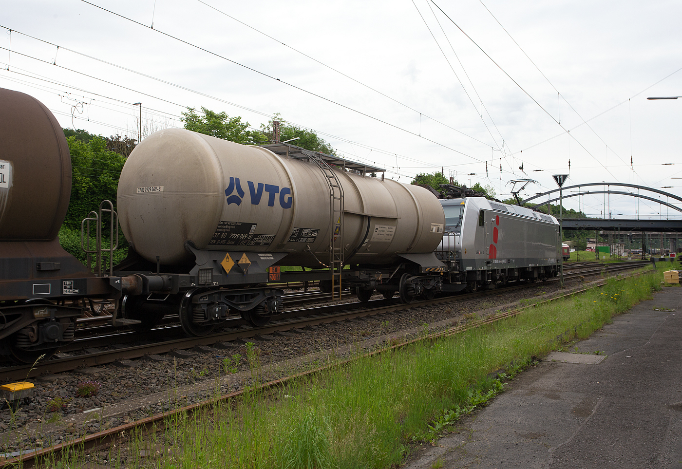 Der vierachsige Drehgestell-Kesselwagen (oben entleerender  Chemiekesselwagen) 37 80 7929 069-8 D-VTG der Gattung Zacns (VTG-Typ C65.060D). der VTG Rail Europe GmbH (Hamburg), laut Gefahrguttafel/Warntafel 58/2014 sowie Anschrift Wasserstoffperoxid wässrige Lösung (H2O2)/Hydrogen peroxide, am 21 Mai 2024 im Zugverband (hinter der Akiem 185 544-4) bei der Zugdurchfahrt in Kreuztal.

Der Wagen wurde 1988 von  LHB (Linke-Hofmann-Busch GmbH) in Salzgitter-Watenstedt gebaut und ist optimiert für den Transport von Wasserstoffperoxid verschiedener Konzentrationen. Der der Tank (Behälter) ist aus austenitischen korrosionsbeständigem Edelstahl (Edelstahl Rostfrei) der Werkstoff-Nr.1.4307 (AISI 304L) gefertigt. Der 1.4307 unterscheidet sich vom Werkstoff 1.4301 durch seinen deutlich verringerten Kohlenstoffgehalt. Beide sind auch als V2A bekannt. Für eine erleichterte Bewegungsfreiheit während der Be- und Entladetätigkeit befindet sich eine große Arbeitsbühne auf dem Wagen/Tank, um die Öffnungen herum. Für die Restmengenentleerung besitzt der Tank eine beidseitige Tankneigung  zur Tankmitte von 1° sowie eine Sumpfmulde.

TECHNISCHE DATEN:
Gattung: Zacns
Spurweite: 1.435 mm (Normalspiur)
Anzahl der Achsen: 4 (in 2 Drehgestellen)
Länge über Puffer : 14.400 mm
Drehzapfenabstand: 9.360 mm
Achsabstand im Drehgestell: 1.800 mm
Laufraddurchmesser: 920 mm (neu)
Höchstgeschwindigkeit: 100 km/h (leer 120 km/h)
Eigengewicht: 19.920 kg
Nutzlast: 70,0 t ab Streckenklasse D
Gesamtvolumen: 62.290  Liter
Tankcode: L4DV 
Behälterabmessung: Ø 2.550 mm x 12.270 mm lang
Behälterwerkstoff : Edelstahl.1.4307
Kleinster befahrbarer Gleisbogen: R= 35 m
Bremse: KE-GP-A (K)
Bremssohle: C810 / Cosid 810 (Komposit-Bremssohle, kurz K-Sohle)
Intern. Verwendungsfähigkeit: TEN-GE

Die Bedeutung der Gattung Zacns:
Z = Kesselwagen
a = 4 Radsatz
c = mit Entladung unter Druck
n = mit vier Radsätzen höchste Lastgrenze über 60 t
s = zugelassen für Züge bis 100 km/h (beladen)

Bedeutung des Tankcode L40DV: 
L = Tank für Stoffe in flüssigem Zustand 
4 = zutreffender Mindestprüfdruck in bar
D = Tank mit obenliegenden Öffnungen ohne Öffnungen unterhalb des Flüssigkeitsspiegels (Befüllen oder Entleeren oben)
V = Tank mit Lüftungseinrichtung ohne Flammendurchschlagsicherung oder
nicht explosionsdruckstoßfester Tank
Max. Betriebsdruck: 3,0 bar

Bedeutung der Warntafel 58/2014: 	
58 (Gefahrnummer) = oxidierender (brandfördernder) Stoff, ätzend
2014 (UN-Nummer) = Wasserstoffperoxid, wässrige Lösung mit mindestens 20 %, aber höchstens 60 % Wasserstoffperoxid (Stabilisierung nach Bedarf)
