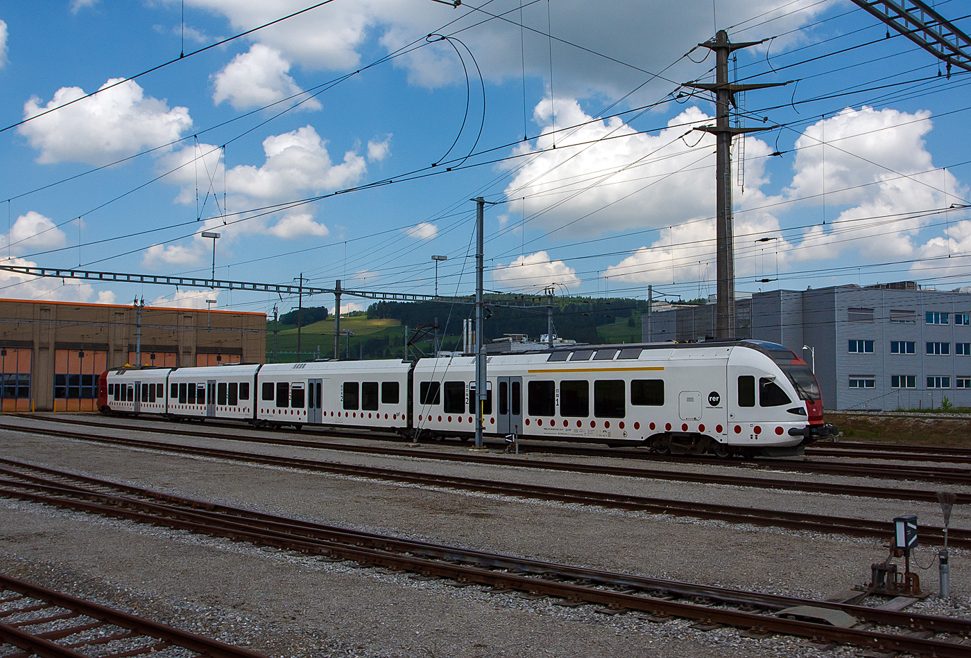 Der vierteilige STADLER Flirt RABe 527 191-6 „Jo Siffert“ ist am 28.05.2012 vor dem Depot in Bulle abgestellt. Das Bild entstand aus einem Zug heraus. 

Die tpf - Transports publics fribourgeois SA (Freiburgische Verkehrsbetriebe AG) entstand zum 01.01.2000 durch die Fusion der ehemalige GMF (Chemins de fer fribourgeois Gruy�re–Fribourg–Morat) mit der TF (Transports en commun de Fribourg SA). Dabei absorbierte die GFM die TF und gab sich den neuen Namen tpf. 

Ab 2011 erneuerten und erweitern die tpf  ihre normalspurige Schienenfahrzeugflotte f�r das neu strukturierte Verkehrsangebot Fribourg–Bulle (RER Fribourg), durch diese vierteiligen Stadler FLIRT – Niederflur-Gelenktriebwagen der BR RABe 527. Die 1. Serie von 4 St�ck (RABe 527 191–194) wurde 2011 und vier Weitere (RABe 527 195–198) wurden 2014 geliefert.

Die FLIRT-Fahrzeuge entsprechen den Bed�rfnissen der TPF und sind zugleich mit den letzten Innovationen in der Eisenbahntechnik ausgestattet. Der FLIRT (Flinker Leichter Innovativer Regional-Triebzug) er�ffnet neue Perspektiven f�r den Regionalverkehr. Sein ger�umiger, mit durchsichtigen Trennw�nden ausgestatteter Fahrgastbereich wurde f�r eine Bahnsteigh�he von 550 mm optimiert. Sein hohes Beschleunigungsverm�gen erg�nzt die aussergew�hnlichen Merkmale dieses Fahrzeugs auf optimale Weise.

Merkmale:
• Helle und einladende Innenbereiche
• Anteil an Niederflurbereich mehr als 90 %
• Gro�fl�chiger Multifunktionsraum in jedem Eingangsbereich
• 4 Einstiegst�ren pro Seite f�r einen schnellen Fahrgastwechsel
• Fahrgastraum und F�hrerstand mit Klimaanlage
• WC mit geschlossenem Kreislauf und Zugang f�r Fahrg�ste mit eingeschr�nkter Mobilit�t.
• Elegantes und ger�umiges Erste-Klasse-Abteil
• Gro�bildschirme zur dynamischen Fahrgastinformation mit Multimediafunktionen
• Aerodynamische GFK-Front, ausgestattet mit automatischer Kupplung
• Wagenk�sten aus Aluminium-Strangpressprofilen
• Luftgefederte Lauf- und Triebdrehgestelle
• Redundante Antriebsausr�stung bestehend aus
4 Antriebsstr�ngen mit wassergek�hlten IGBT-Stromrichtern
• Mehrfachtraktion von bis zu 4 Einheiten

TECHNISCHE DATEN:
Spurweite: 1.435 mm (Normalspur)
Achsanordnung: Bo' 2' 2' 2' Bo'
L�nge �ber Kupplung: 74.078 mm
Fahrzeugbreite: 2.880 mm 
Fahrzeugh�he: 4.150 mm 
Achsabstand im Drehgestell: 2.700 mm 
Triebraddurchmesser, neu:  870 mm 
Laufraddurchmesser, neu: 750 mm 
Fu�bodenh�he Niederflur am Einstieg: 600 mm 
Fu�bodenh�he Hochflur: 1.120 mm 
Einstiegbreite: 1.300 mm
Dauerleistung am Rad: 2.000 kW
Max Leistung am Rad:  2.600 kW
Anfahrzugskraft bis 47km/h: 200 kN 
Dienstgewicht: 122 t
H�chstgeschwindigkeit:160 km/h
Sitzpl�tze: 167 
Klappsitze: 42  
Speisespannung: 15 kV AC, 16.7 Hz

Quelle: Stadler Rail
