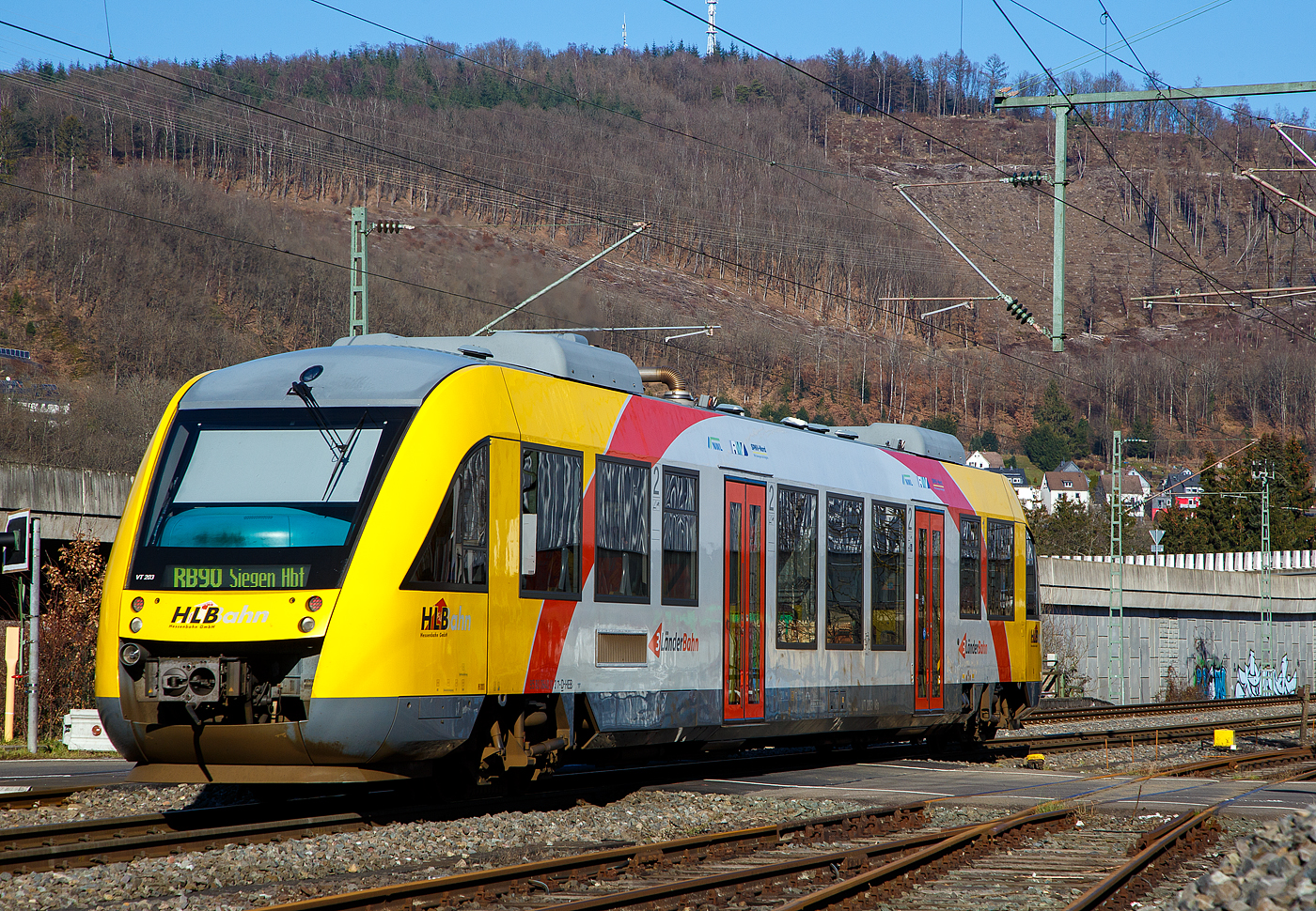Der VT 203 ABp (95 80 0640 103-7 D-HEB), ein Alstom Coradia LINT 27 der HLB, ex vectus VT 203, verl�sst am 14.02.2023, als RB 90  Westerwald-Sieg-Bahn   (Limburg/Lahn - Westerburg – Altenkirchen - Au/Sieg - Siegen), Niederschelden (eigentlich Niederschelderh�tte) und f�hrt weiter in Richtung Siegen.

Der Alstom Coradia LINT 27 wurde 2004 von der ALSTOM Transport Deutschland GmbH (vormals LHB - Linke-Hofmann-Busch GmbH) in Salzgitter-Watenstedt unter der Fabriknummer 1187-003 gebaut und an die vectus Verkehrsgesellschaft mbH, mit dem Fahrplanwechsel am 14.12.2014 wurden alle Fahrzeuge der vectus nun Eigentum der HLB