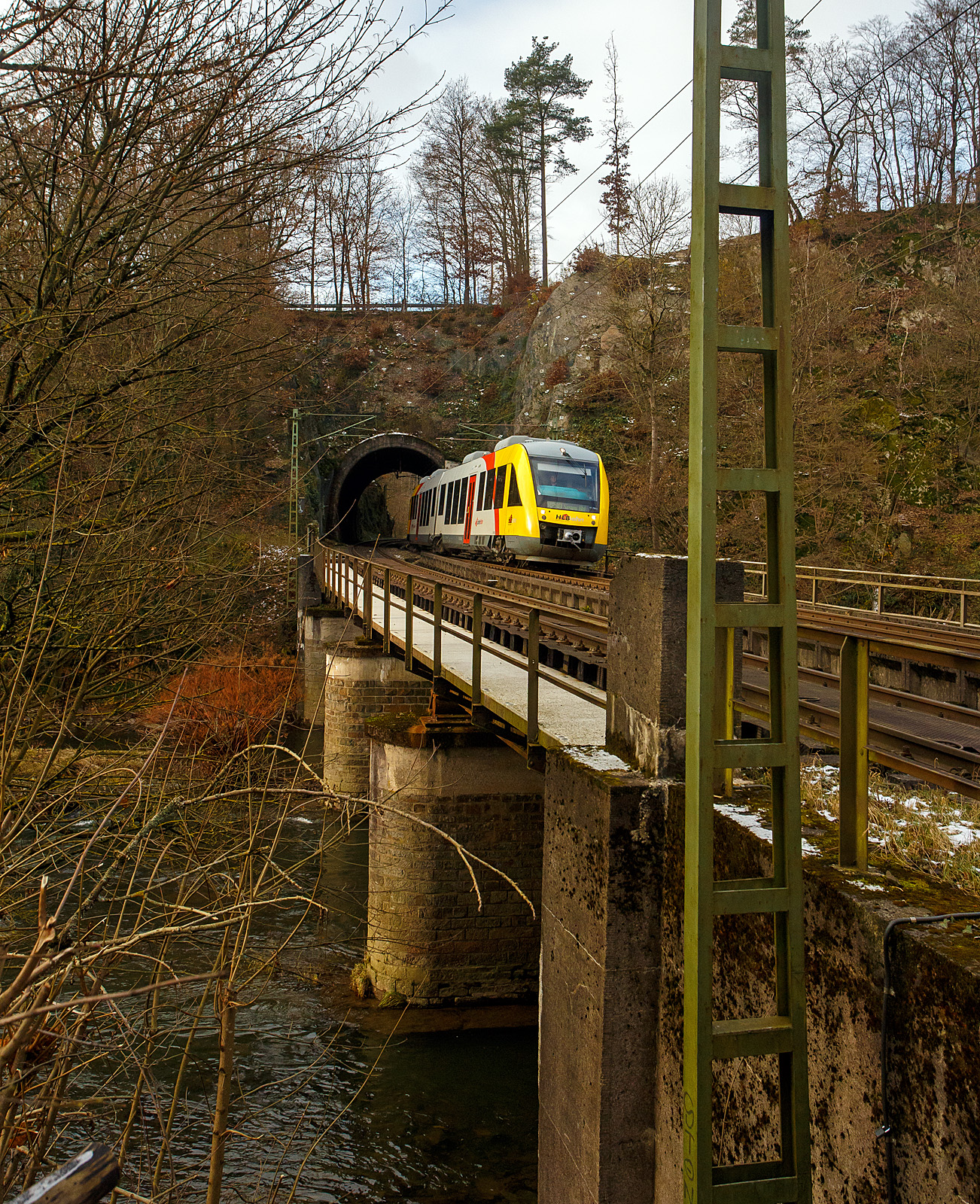 Der VT 256 (95 80 0648 156-7 D-HEB / 95 80 0648 656-6 D-HEB), ein Alstom Coradia LINT 41 der HLB - Hessische Landesbahn (3LänderBahn), hat als RB 90 „Westerwald-Sieg-Bahn“ , der Verbindung Altenkirchen(Westerwald) – Au(Sieg) - Betzdorf(Sieg) – Siegen Hbf, auf der Siegstrecke (KBS 460) bei km 79,4 den 32 m langen Mühlburg-Tunnel und fährt nun auf die Siegbrücke und erreicht bald den Bahnhof Scheuerfeld (Sieg) am 02.12.2023.

Durch eine Weichenstörung beim Bahnhof Scheuerfeld, die schnell behoben wurde, fährt er hier heute mal links.