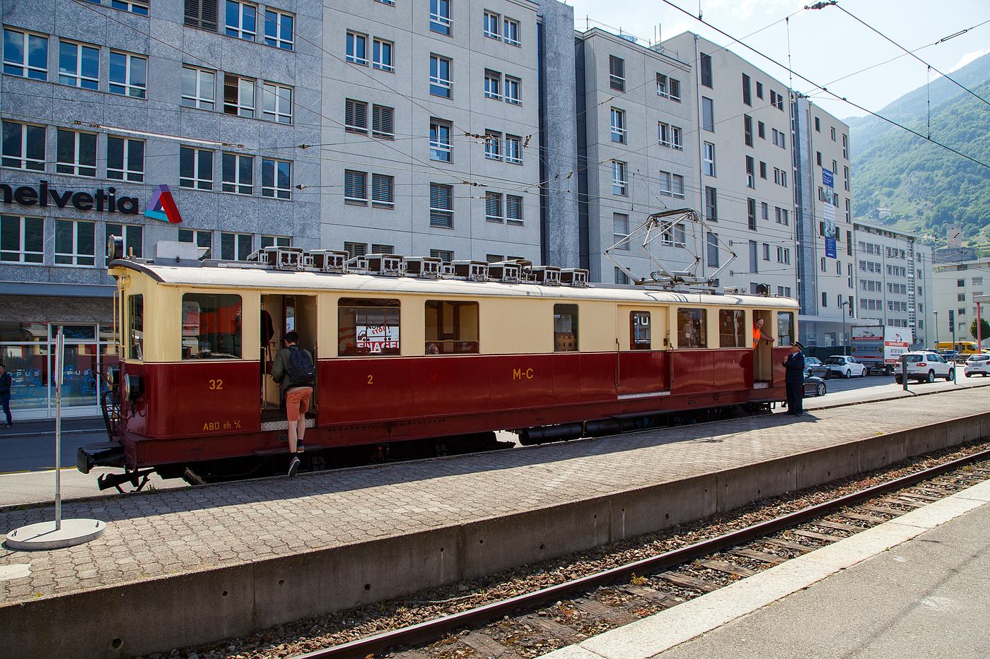 Der wunderschöne ehemalige Martigny-Châtelard-Bahn (MC) Triebwagen ABDeh 4/4 32  le tracteur  ( der Traktor ) vom Verein Train Nostalgique du Trient, ex MC BCFe 4/4, ex SBB CFeh 4/4 N°32 Baujahr 1921, am 26. Mai 2023 im Bahnhof Martigny.

Der Förderverein TNT Train Nostalgique du Trient wurde 1995 wurde 1995 gegründet, dieser bezweckt die alten Fahrzeuge der Schmalspurbahn Martigny-Châtelard-Bahn (MC) im betriebsfähigem Zustand zu halten.

Der meterspurige elektrische Personentriebwagen mit Gepäckabteil für gemischten Zahnrad- und Adhäsionsbetrieb ABDeh 4/4 32 wurde 1921 als CFeh 4/4 für die SBB (für Materialtransporte von der SBB-Station Martigny zum MC-Bahnhof Le Châtelard-Giétroz) gebaut. Während der Arbeiten am Barberine-Staudamm der SBB wurde die Martigny-Châtelard als Transport von Personal und Material ausgewählt. Da die MC (Martigny-Châtelard-Bahn) jedoch nicht über ausreichend Rollmaterial verfügte, bestellt die SBB zwei CFeh 4/4-Triebwagen Nr. 31 und 32. Die Triebwagen mit einer Leistung von 295 kW, waren zum Ziehen von Güterzügen konzipiert (daher auch ihr Spitznamen „der Traktor“), verfügten aber auch über ein großes Frachtabteil sowie ein Fahrgastabteil mit 16 Sitzplätzen in der 3. Klasse. Hersteller der für das Zahnstangensystem Strub konstruierten Triebwagen waren die SWS - Schweizerischen Waggonfabrik Schlieren (mechanischen Teil), die Schweizerischen Lokomotiv- und Maschinenfabrik in Winterthur (Drehgestelle) und die MFO - Maschinenfabrik Oerlikon (elektrische Teil). Neben diesem Triebwagen 32 wurde noch ein weiterer mit der Nr. 31 gebaut, dieser wurde im Herbst 2011 nach Vandalismus und Beschädigung leider abgebrochen. Bis 1926 waren die beiden Triebwagen 31 und 32 Eigentum der SBB (CFF). 

Nach Abschluss der Arbeiten im Jahr 1926 wurden die Triebwagen von der MC übernommen (gekauft) und mit einem zusätzlichen Fahrgastraum der 2. Klasse mit 16 Sitzplätzen ausgestattet und in BCFeh 4/4 umbenannt, nach der Klassenreform dann zu ABDeh 4/4. Seit 1996 ist der Triebwagen beim Verein Train Nostalgique du Trient

Ehemaligebezeichnungen:
SBB / CFF CFeh 4/4 - 32 (bis 1926)
MC CFeh 4/4 – 32 (bis 1935)
MC BCFeh 4/4 – 32 (ab 1935)
MC ABFZeh 4/4 - 32
MC ABDeh 4/4 - 32 (ab 1962)

TECHNISCHE DATEN:
Hersteller: SWS, MFO, SLM
Gebaute Anzahl: 2
Spurweite: 1.000 mm (Meterspur)
Achsfolge: Bozz' Bozz'
Zahnstangensystem: Strub (bzw. Riggenbach)
Länge über Kupplung: 15.940 mm 
Drehzapfenabstand: 7.850 mm 
Breite: 2.700 mm
Höhe: 3.400 mm
Leergewicht: 40,5  t
Dienstgewicht: 43 t
Leistung: 4 x 100 PS = 400 PS (295 kW)
Höchstgeschwindigkeit mit Adhäsionsantrieb: 28 km/h
Höchstgeschwindigkeit mit Zahnradantrieb: 9 km/h 
Antriebsart: Elektrisch über Oberleitung oder seitlicher Stromschiene
Fahrleitungsspannung: 850 V DC (=) (ursprünglich 750 V DC)
Sitzplätze: 32 (je 16 in der 1. und 2. Klasse)
Beschaffungspreis: 49.779.- Franken

Die Martigny-Châtelard-Bahn (Streckennummer 132), abgekürzt MC, (französisch: Chemin de fer Martigny–Châtelard) ist eine 18 km lange meterspurige Bahnstrecke mit Zahnstangenabschnitten (System Strub) mit bis zu 200 ‰ Neigung, in den Adhäsionsabschnitten mit bis zu 70 ‰ Neigung. Die Strecke führt Martigny, Vernayaz MC, Salvan, Les Marécottes, Finhaut und Le Châtelard VS bis zum französischen Bahnhof Vallorcine. In Frankreich verläuft dann die 34 km lange SNCF-Strecke (SNCF KBS 514) von Vallorcine über Chamonix-Mont-Blanc (Anschluss zur Montenvers-Bahn) nach Saint-Gervais-Le Fayet.
