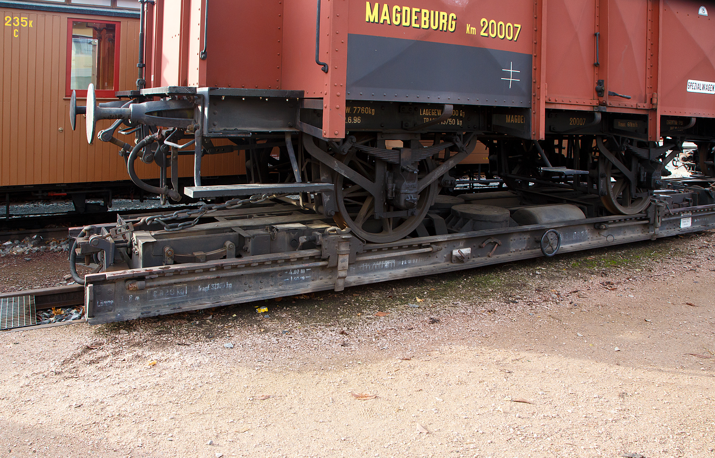 Detailbild von dem 2-achsiger normalspuriger kurzer preußischer Klappdeckelwagen, der Königlich Preußischen Eisenbahn-Verwaltung (KPEV) Magdeburg Km 20007, (Güterwagen der Verbandsbauart), verladen auf dem 4-achsigen schmalspurigen 7,8 m Rollbockwagen ex DR 97-08-73, der Gattung Rf 4 (Sächs. Gattung 816), von der Traditionsbahn Radebeul e.V. derzeit (hier am 07.12.2022) aufgestellt am Museumsgleis 6 in Radebeul Ost. Der historische Regelspur-Güterwagen ist Eigentum vom Verkehrsmuseums Dresden.