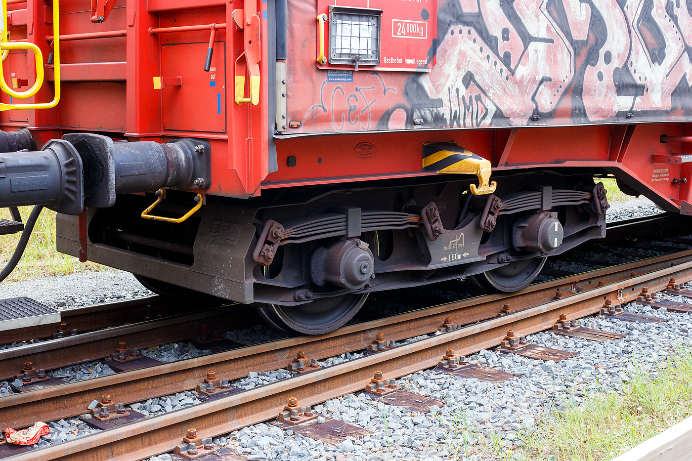 Detailbild eines zweiachsigen Güterwagen-Drehgestells mit Radsatzlast 22,5 t der Bauart LHB 82 (DB BA 589) mit Parabelfedern, hier von dem vierachsiger Drehgestell-Flachwagen mit verschiebbarem Planenverdeck und Lademulden für Coiltransporte, 31 80 4676 380-7 D-DB, der Gattung Shimmns-ttu 708.4, der DB Cargo, hier  am 12 September 2024 im Zugverband, auf dem KSW Rbf in Herdorf (Betriebsstätte Freien Grunder Eisenbahn - NE 447). Aufnahme vom öffentlichen Geh- und Radweg. Auch wenn der Wagen 1991unter der Fabriknummer 392 von LHB - Linke-Hofmann-Busch GmbH in Salzgitter-Watenstedt gebaut wurde, ist dieses Drehgestell 1991von Talbot in Aachen gebaut worden.

TECHNISCHE DATEN des Drehgestells:
Spurweite: 1.435 mm (Normalspur)
Gewicht: 4.800 kg
Achsabstand: 1.800 mm
Max. Achslast: 22,5 t
Für Wagen (bremstechnisch) bis Geschwindigkeit max. Achslast 22,5 t: 100 km/h
Für Wagen (lauftechnisch) bis Geschwindigkeit max. Achslast 22,5 t: 120 km/h