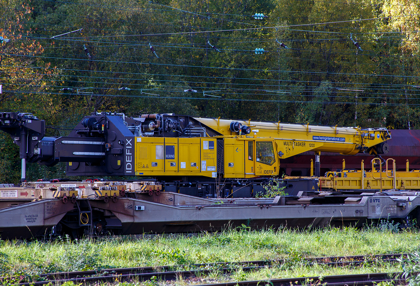 Detailbild vin dem 150 t Gleis- und Eisenbahndrehkran (EDK) KIROW Multi Tasker KRC 1200, D-HGUI 99 80 9419 041-5 „IDEFIX“ der HERING Bahnbau GmbH in Burbach-Holzhausen, ist am 18 Oktober 2025 im Rbf Betzdorf/Sieg abgestellt. Leider stehen noch auf den Gleisen davor andere Wagen. Nach der Gewichtsklasse hätte der Kran eher den Namen „Obelix“ verdient und nicht den Namen nach Hund von Obelix „Idefix“. 