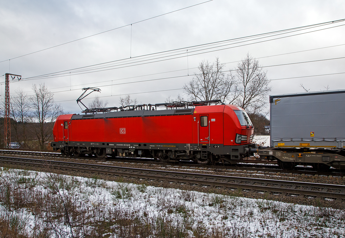 Die 193 323-3 (91 80 6193 323-3 D-DB) der DB Cargo AG f�hrt am 27.01.2023 mit einem „HUPAC“ KLV-Zug durch Rudersdorf (Kr. Siegen) in Richtung Siegen. Hier bef�hrt der Zug die Dillstrecke (KBS 445) von dieser geht es bei Siegen-Ost auf die Siegstrecke (KBS 460) in Richtung K�ln. Weil die Ruhr-Sieg-Strecke (KBS 440) nicht das KV-Profil P/C 400 aufweist, sind solche Z�ge dort nur bis Kreuztal zum S�dwestfalen Container-Terminal m�glich.

Die Siemens Vectron MS (200 km/h - 6.4 MW) wurden 2018 von Siemens unter der Fabriknummer 22448 und gebaut, sie hat die Zulassungen f�r Deutschland, �sterreich, Schweiz, Italien und die Niederlande (D/A/CH/I/NL).