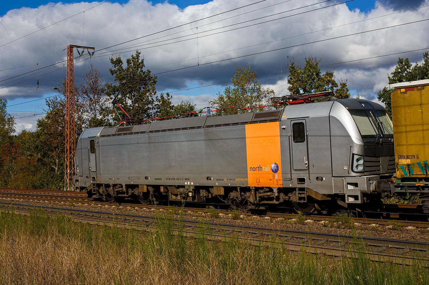 Die 193 922-2 (91 80 6193 922-2 D-NRAIL)  der Northrail GmbH fährt am 05 September 2024 mit einem KLV-Zug durch Wilnsdorf-Rudersdorf (Kr. Siegen) in Richtung Siegen,

Die Siemens Vectron AC wurde 2010 von SIEMENS in München-Allach unter der Fabriknummer 21695 gebaut und auf der InnoTrans 2010 in Berlin präsentiert. Sie war ursprünglich eine Vorführ-/Mietlok der Siemens Mobility in München, eingestellt durch die RailAdventure GmbH als 91 80 6193 922-2 D-RADVE. Im Jahr 2012 wurde sie durch SIEMENS umgebaut, dabei erhielt sie temporär eine Last-Mile Dieseleinheit und wurde in 91 80 6192 961-1 D-PCW umgezeichnet (damals war die BR 192 noch frei). So wurde sie, als Vectron mit LM auf der InnoTrans 2012 in Berlin präsentiert. Im Dezember 2012 wurde sie dann in die Vectron AC Variante B03 (D / A / H) zurück gebaut und zur 91 80 6193 922-2 D-PCW umgezeichnet.

Im Dezember 2013 die Paribus Rail Portfolio III GmbH & Co. KG (Hamburg) verkauft und in die Vectron AC Variante B06 für Schweden umgebaut und über Railpool als 91 80 6193 922-2 D-Rpool eingestellt und wurde an die SkJb - Skandinaviska Jernbanor AB nach Schweden vermietet, später war sie für die Hector Rail AB in Schweden unterwegs. 

2018 ging sie dann wieder nach Deutschland und wurde durch Siemens in München in die heutige Vectron AC B01 Variante (Zulassung Deutschland und Österreich) umgebaut und in 91 80 6193 922-2 D-NRAIL umgezeichnet. Eigentümer ist die Paribus Rail Portfolio III GmbH & Co. KG, die die LOKS für die Northrail GmbH finanziert.
