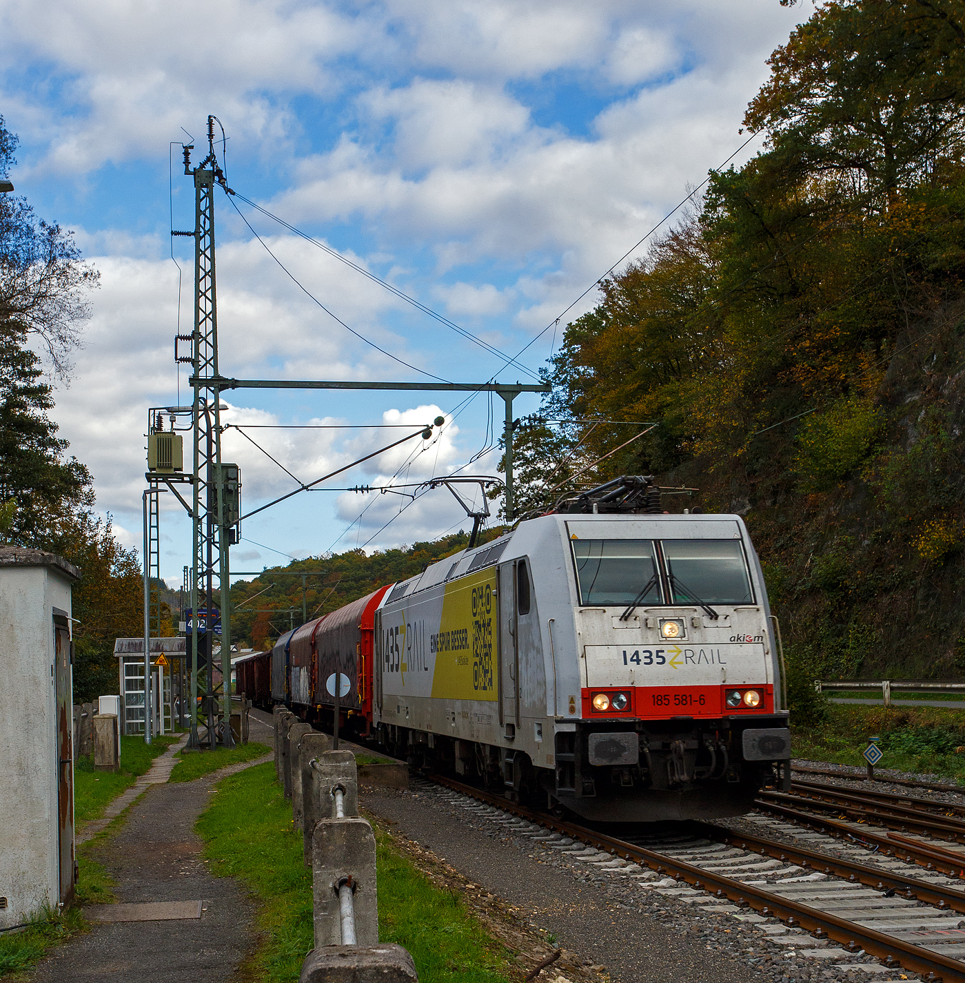 Die an die 1435 railway operations GmbH & Co. KG (Erfurt) vermietete 185 581-6 (91 80 6185 581-6 D-AKIEM) der Akiem S.A.S. mit Sitz in Saint-Ouen bei Paris, fährt am 18 Oktober 2025 mit einem kurzen gem. Güterzug (6 Wagen) durch Scheuerfeld/Sieg in Richtung Köln. 

Die TRAXX F140 AC2 wurde 2007 von Bombardier in Kassel unter der Fabriknummer 34163 gebaut und an die CBRail S.à r.l. (Luxembourg) geliefert. Lange war sie an die Crossrail AG vermietet und fuhr für diese als 91 80 6185 581-6 D-XRAIL  Celine Alia . Zum 04.01.2013 wurde aus CBRail die Macquarie European Rail Ltd, zum 23.04.2020 übernahm dann die Akiem das Leasinggeschäft der Macquarie und somit auch die Schienenfahrzeuge.

Die Lok hat die Zulassungen für Deutschland, Österreich und die Schweiz (DACH), sie hat auch vier Stromabnehmer. 