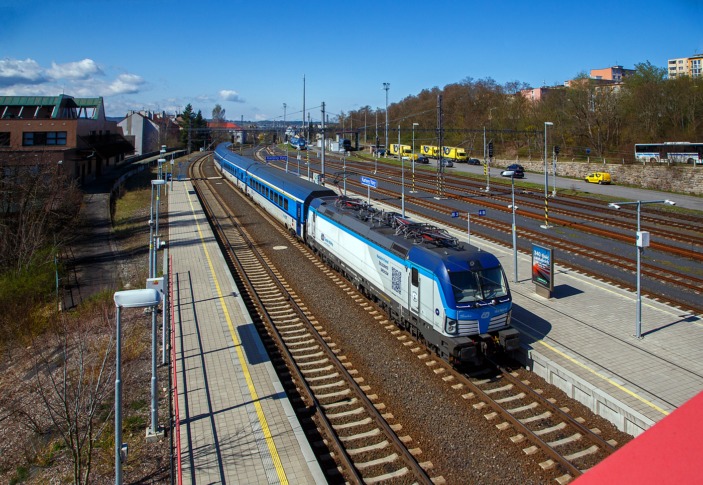 Die an die ČD - České dráhy (Tschechischen Eisenbahnen) vermietete Siemens Vectron MS 193 963-6  Filinchen  (91 80 6193 963-6 D-RAILL) der S Rail Lease s.r.o. / Rolling Stock Lease s.r.o.(Bratislava, Slowakei) fährt am 19.04.2023, mit dem R15 „Krušnohor“ (R611) Cheb - Sokolov - Karlovy Vary -Chomutov - Ústí nad Labem hl.n. - Praha hl.n., in den Bahnhof Karlovy Vary (Karlsbad) ein. Die Zuggattung R steht für Rychlík (ein langsamer Schnellzug).

Die Siemens X4E bzw. Siemens Vectron MS wurde 2020 von Siemens Mobilitiy in München-Allach unter der Fabriknummer 22761 gebaut. Die Vectron MS – Variante A01 mit einer Leistung von 6.4 MW (unter Wechselstrom) mit einer zugelassenen Höchstgeschwindigkeit für 200 km/h hat die Zulassungen für Deutschland, Österreich, Slowakei, Rumänien, Polen, Tschechien und Ungarn (D/A/SK/RO/PL/CZ/H).

Die gezogenen Wagen ist eine fünfteilige, zwischen 2019 und 2022 von Siemens Wien (Fertigung) und ŠKODA VAGONKA Ostrava (Montage) gebaute, InterJet-Wageneinheit (UIC-Z-Wagen).

