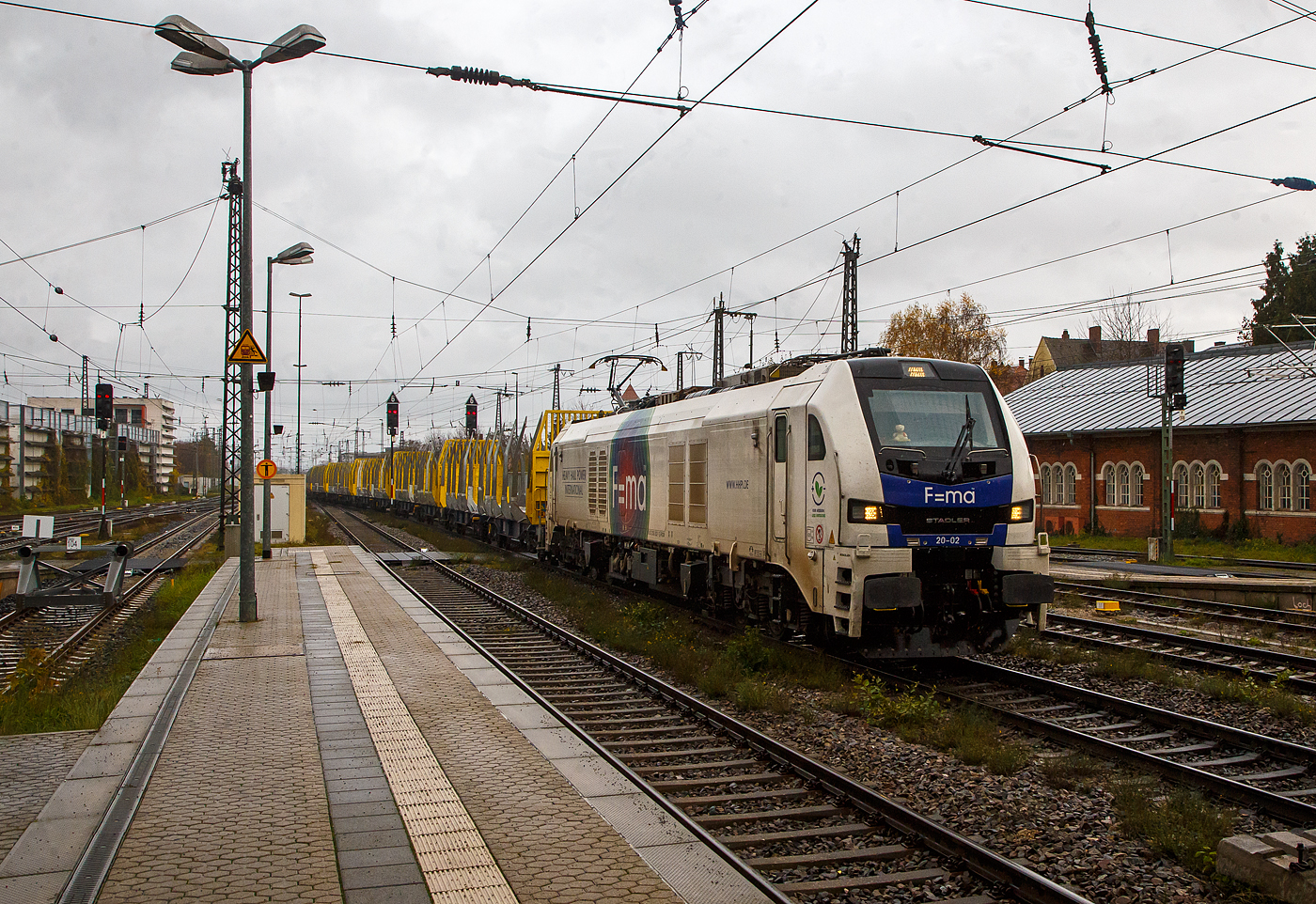 Die an die HHPI - Heavy Haul Power International GmbH (Erfurt) vermietete F=ma 20-02 bzw. 159 202- 1(90 80 2159 202-1 D-RCM), eine sechsachsige Stadler EURO DUAL der ELP - European Loc Pool AG (Frauenfeld/Schweiz), eingestellt in Deutschland durch die RCM Rail Care and Management GmbH (München), fährt am 24.11.2022 mit einem leeren Holzzug (Wagen der Gattung Sggmrrs der österreichischen Innofreight Speditions GmbH) durch den Hauptbahnhof Regensburg in Richtung Nürnberg.

Die EURO DUAL eine Co'Co'- Lok wurde 2019 von Stadler Rail Valencia S.A.U. (Spanien) unter der Fabriknummer  3964 gebaut und an die ELP - European Loc Pool AG in Frauenfeld (CH) ausgeliefert. Sie hat die Zulassungen für Deutschland und Österreich.

Die im Logo und auf den Lokomotiven dargestellte Formel F=ma bezieht sich auf das Zweite Newtonsche Gesetz was bedeutet: Kraft = Masse mal Beschleunigung.

Diese neue sechsachsige Hybridlokomotive ist mehr als nur eine Lokomotive für die  letzte Meile  und bietet zwei Lösungen in einem. Sie kann auf elektrifizierten und nicht-elektrifizierten Strecken eingesetzt
werden. Während der Fahrt ist es möglich, von der elektrischen Oberleitung auf Diesel umzuschalten. Die Euro Dual können auf elektrifizierten Strecken mit 15 kV 16,7 Hz und 25 kV 50 Hz eingesetzt werden, sie haben im elektrischen Betrieb eine Leistung von 6.150 kW. Für nicht elektrifizierte Strecken besitzt die EuroDual einem leistungsstarken Dieselmotor mit 2.800 kW Leistung, die Traktionsleistung (Leistung am Rad) beträgt 2.350 kW.

TECHNISCHE DATEN:
Spurweite: 1.435 mm (Normalspur)
Achsanordnung: Co’Co’ 
Länge über Puffer: 23.020 mm
Drehzapfenabstand: 14.000 mm
Breite: 2.900 mm
Höhe: 4.290 mm
Achsabstand im Drehgestell: 3.600 mm (2 x 1.800 mm)
Treibdurchmesser: 1.067 mm (neu)
Eigengewicht: 123 t
Achslast: 21 t
Höchstgeschwindigkeit: 120 km/h
Elektrische Leistung am Rad bei 25 kV 50 Hz: 7.000 kW
Elektrische Leistung am Rad bei 15 kV 16.7 Hz: 6.150 kW
Leistung bei Dieselantrieb: 2.800 kW (3.807 PS)
Anfahrzugkraft: 500 kN
Elektrische Bremskraft	: 240 kN

Dieselmotor: 
Motorbauart: Caterpillar  V-16-Viertakt-Dieselmotor mit Abgasturbolader und Ladeluftkühlung  vom Typ CAT C175-16
Motorleistung: 2.800 kW (3.807 PS)
Motornenndrehzahl: 1.800 U/min
Hubraum: 84,67 l (Bohrung Ø 175 mm / Hub 220 mm)
Motorgewicht (trocken): ca. 13.000 kg
Motorabmessung: 4.515 x 1.845 x 2.478 mm (l x b x h)
Abgasnorm: IIIB

Anzahl der Fahrmotoren: 6
Antrieb: elektrisch oder dieselelektrisch
Speisespannung: 25 kV 50 Hz und 15 kV 16.7 Hz
Tankinhalt Diesel: 3.500 l
Tankinhalt Urea: 400 l (für Abgasbehandlung selektive katalytische Reduktion („AdBlue“))
Bremse: KE-GP-E mZ (D)
Bremssystem Mechanisch: Pneumatisch 
Bremssystem Dynamisch: Regenerativ/Rheostatisch
Primär Federung: Schraubenfedern
Sekundär Federung: Gummi-Metall Vertikal- und Horizontaldämpfer
Zugbeeinflussung: PZB, ETCS

Quellen: ELP, Stadler Rail und CAT
