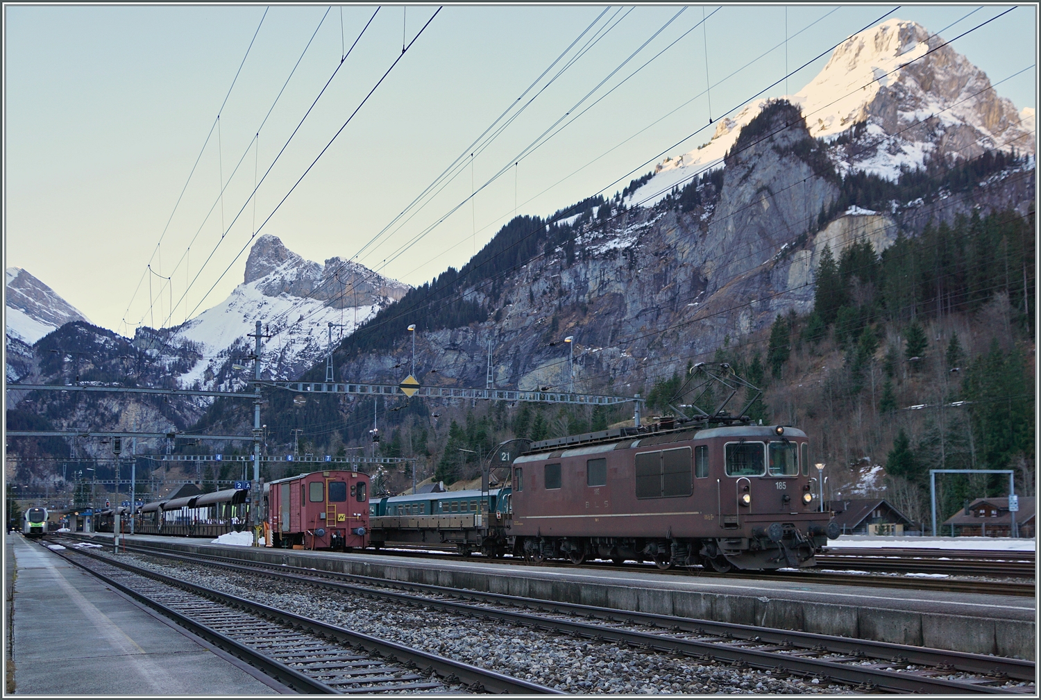 Die Autotunnelzüge der Strecke AT1 (und AT2 in der Hochsaiseon) nach Kandersteg (bzw. Iselle) sind im Bahnhof von Kandersteg fotografisch gesehen an einer sehr ungeschickt Stelle zu finden und somit kaum fotografier bar. Die Strecke bis zum Tunnel bietet jedoch gute Möglichkeiten, die letzten im Einsatz befindlichen BLS Re 4/4 zu fotografieren.
Ich blieb trotzdem an Bahnhof von Kandersteg und konnte die BLS Re 4/4 185 mit ihrem Autotunnelzug im Bahnhof fotografieren. Der Zug wartet auf die Abfahrt des BLS RABe 521 als R1 von Domodossola nach Bern, um dann als Dienstzug in Richtung Frutigen zu fahren. 

3. Jan. 2024