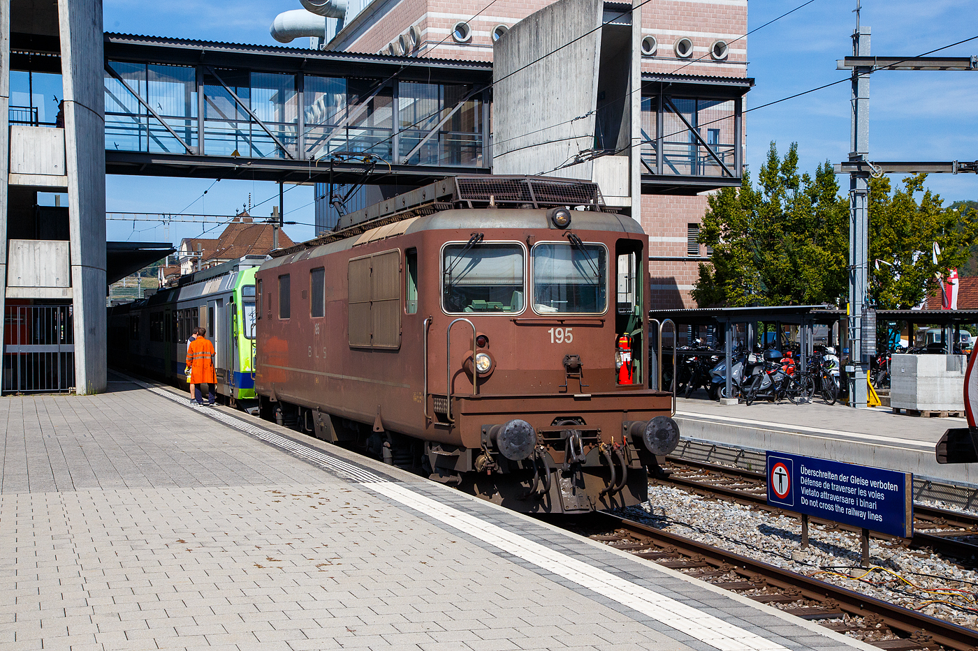 Die BLS Re 4/4 - 195 / Re 425 195-5  Unterseen  (91 85 4425 195-5 CH-BLS) hat am 11 September 2023 den BLS NPZ - RBDe 565 729 in den Bahnhof Spiez rangiert. 

Die Lok ist die letzte der Baureihe und wurde 1983 bei SLM unter der Fabriknummer 5227 gebaut, die elektrische Ausrüstung ist von BBC.

Die Loks wurde als Universallokomotive mit guter Bergleistung beschafft, um die Züge mit höheren Geschwindigkeiten befördern zu können und um die Lokomotiven der Gründungsjahre abzulösen. Die Dauerleitung der Koks beträgt 4.980 kW (6.770 PS).

Die Re 4/4 ist eine Neuentwicklung der BLS und SLM aufgebaut auf die Ae 4/4, der ersten laufachslosen Hochleistungslokomotive der Welt. Das ist an der Kastenform eindeutig zu erkennen, die Einstiege an der Lokfront wurde von der Ae 4/4 übernommen. Das Fahrgestell ist ähnlich demjenigen der SBB Re 4/4 II. Doch schon da hören die Gemeinsamkeiten zu dieser auch sehr erfolgreichen Baureihe auf. So wird die Kraft mit einer anders konstruierten Tiefzuganlenkung und Seilzug auf die Schienen gebracht. Statt Sandereinrichtungen besitzt die Lok Schienendüsen. Bei vielen Versuchen mit z. T. ausländischen Lokomotiven stellt die Re 4/4 noch heute ihre enorme Leistungsfähigkeit am Berg unter Beweis. Einen 630-Tonnen-Zug kann die Lok auf einer 26-‰-Steigung mit 80 km/h befördern.

TECHNISCHE DATEN der Re 4/4 174 bis 195:
Spurweite: 1.435 mm (Normalspur)
Achsformel: Bo’Bo’
Länge über Puffer:  15.470 (15.100 mm Lok 161 bis 173)
Drehzapfenabstand: 7.900 mm
Achsabstand im Drehgestell: 2.800 mm
Treibraddurchmesser: 1.250 mm
Höhe: 4.500 mm
Breite: 2.950 mm
Dienstgewicht:  80 t
Höchstgeschwindigkeit: 140 km/h
Dauerleistung:  4.980 kW (6.770 PS)
Anfahrzugkraft:  320 kN
Dauerzugkraft: 236 kN
Anzahl Fahrmotoren: 4
Übersetzungsverhältnis: 1 : 3,346
Stromsystem:  Wechselstrom 15 kV 16,7 Hz