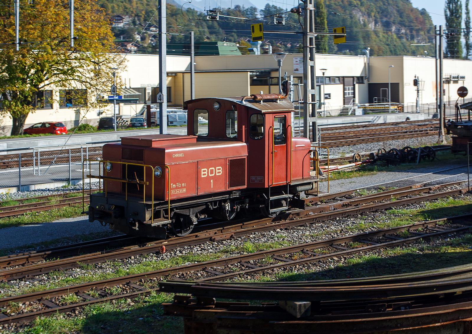 Die BOB dieselelektrische Rangierlok Tm 2/2 1 „CHRIGEL“  am 02.10.2011 vor dem Depot der Ballenberg Dampfbahn. Aufnahme aus einem fahrenden Zug.

Die Lok wurde 1946 von Ernst Stadler in Zürich gebaut, Zulieferer waren Saurer (Dieselmotor), BBC/MFO und SIG.

TECHNISCHE DATEN:
Spurweite: 1.000 mm
Achsfolge: B zz
Zahnstangensystem: Riggenbach
Länge: 6.860 mm
Breite: 2.720 mm
Höhe: 3.150 mm
Dienstgewicht: 15 t
Leistung: 120 kW
Höchstgeschwindigkeit: 30 km/h (35 km/h Schleppfahrt)