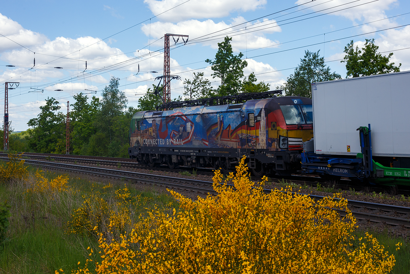Die bunte und schöne Siemens Vectron MS X 4 E – 640 / 193 640-0 “Connected by Rail” (91 80 6193 640-0 D-DISPO) der Beacon Rail Capital Europe GmbH, München (BRCE / DISPO) fährt am 16 Mai 2025 mit dem HELROM Trailer Zug Wien – Düsseldorf, einem besonderen KV-Zug, durch Ruderdorf (Kr. Siegen), via Siegen, in Richtung Köln. Leider war die Lok hier nicht ganz sauber, zudem war eine Wolke vor der Sonne.

Die Siemens Vectron MS - 6.4 MW wurde 2016 von Siemens in München-Allach unter der Fabriknummer 22164 gebaut. Sie ist in der Variante A09 ausgeführt und hat so die Zulassungen für Deutschland, Österreich und Italien (D / A / I), daher trägt sie auch die Werbung München, Kufstein, Verona (Connected by Rail). Sie hat eine Höchstgeschwindigkeit von 160 km/h.

Die Lok wurde an die MRCE - Mitsui Rail Capital Europe GmbH in München ausgeliefert, seit September 2023 hat die Beacon Rail Metro Finance B.V. die Mitsui Rail Capital Europe B.V. (Amsterdam) und somit auch die Mitsui Rail Capital Europe GmbH im München übernommen, so firmiert sie nun als Beacon Rail Capital Europe GmbH, München (BRCE / DISPO).
