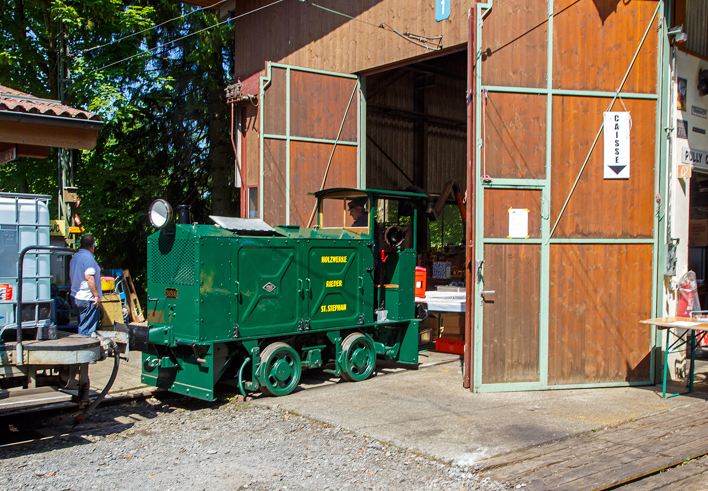 Die doch recht kleine ex MOB Schienentraktor Tm 2/2 Nr. 1, ex Holzwerk Rieder, der Museumsbahn Blonay-Chamby am 27.05.2023 im Museumsareal in Chaulin. Dahinter der kleine ex MOB Schienentraktor Tm 2/2 Nr. 1, ex Holzwerk Rieder, der Museumsbahn.

Die kleine Diesellok, vom Typ O&K RL 2a wurde 1931 von Orenstein & Koppel im Werk Babelsberg unter der Fabriknummer 20200 gebaut und an die Grande Dixence SA für die Baustelle der ersten Dixence-Staumauer  geliefert, wo sie bis 1940 im Einsatz war. Im 1941 wurde sie dann von der Firma Mauerhofer & Zubner, für den Einsatz von Bauzügen beim Fahrleitungsumbau bei der MOB übernommen. 1950 wurde die kleine Lok an das Holzwerk Rieder in St. Stephan verkauft, diese Farbgebung trägt sie auch aktuell bei der BC. Die Lok trägt Fabrikschilder der MBA, wobei die Umbenennung der O&K in Maschinenbau und Bahnbedarf Aktiengesellschaft, vormals Orenstein & Koppel (MBA) erst im Februar 1940 erfolgte.

Die MOB (Montreux-Berner Oberland-Bahn / Montreux Oberland Bernois) kaufte die Lok dann 1979 wieder zurück und bezeichnete sie als Tm 2/2 1. Bei der MOB wurde sie für Rangierarbeiten, von Zementwagen auf Rollböcken in St. Stephan eingesetzt. Die Lok wurde 1995 von der MOB ausrangiert verbleib aber erst noch im Depot Montbovon. 2006 ging sie dann an die Museumsbahn Blonay-Chamby.

Die Lok hat einen 2-Zylinder-Orenstein & Koppel-Dieselmotor mit 22 PS (16 kW) Leistung, die Leistungsübertragung erfolgt über ein Zweigang-Konuskupplungs-Wendegetriebe mit stufenloser Geschwindigkeit Regulierung, über zwei Rollenketten auf die vordere Achse und von dieser über eine Rollenkette auf die hintere Achse. Das Zweigang-Konuskupplungsgetriebe ermöglicht zwei verschiedene Geschwindigkeitsstufen für beide Fahrtrichtungen. Dabei laufen immer beide Gänge im Eingriff, jeweils einer wird eingekuppelt. Eine einfache Wendeschaltung im Getriebe ermöglicht den Fahrtrichtungswechsel bei Stillstand der Lokomotive. Die einfache Bauart des Getriebes hat sich schon bei den Benzinloks bewährt und wurde bei fast allen O&K-Loks der unteren Leistungsklassen angewendet.

TECHNISCHE DATEN:
Spurweite: 1.000 mm (Meterspur)
Achsfolge: B
Länge über Puffer: 4.490 mm
Kastenlänge: 3.450 mm
Höhe: 2.270 mm
Breite: 1.240 mm
Achsabstand: 1.170 mm
Raddurchmesser : 550 mm
Eigengewicht: 7.000 kg
Leistung: 16 kW (22 PS)
Höchstgeschwindigkeit: 7 km/h
Achslager: Gleitlager

Die O&K Typenbezeichnung  RL  stand für  Rohöl  (= Diesel).

Anfang des 20. Jahrhunderts war es noch üblich bei und auf Großbaustellen Feld- oder Schmalspurbahnen zu bauen und zu betreiben. Heute durch Entwicklung von moderner und oft sehr schweren Baumaschinen und Muldenkipper eigentlich undenkbar.