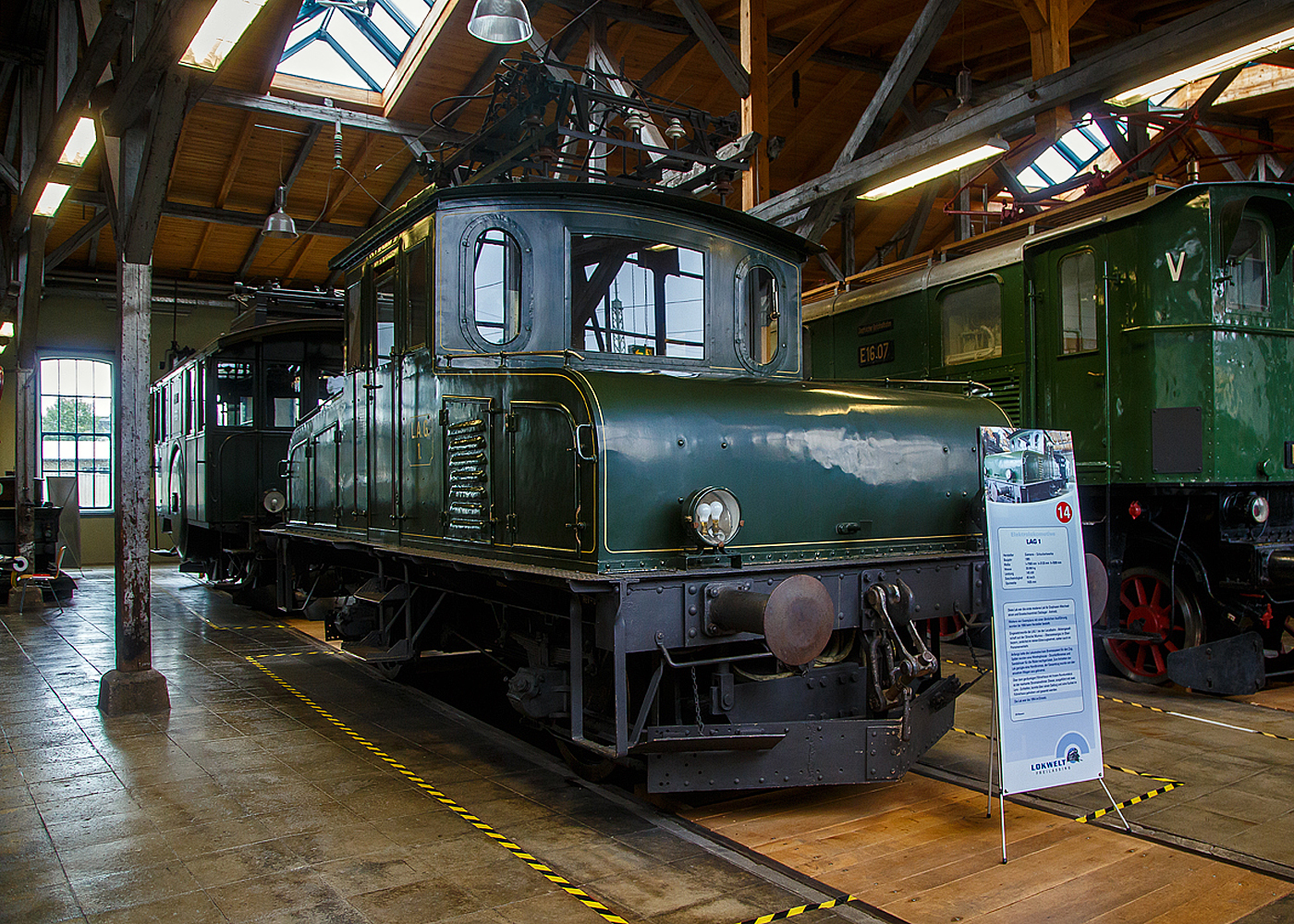 Die Elektrolokomotive LAG 1 „Katharina“ (später DR E 69 01 bzw. DB E 69 01) der ehemaligen Lokalbahn Aktien-Gesellschaft (LAG) am 11.09.2022 in der Lokwelt Freilassing.

Im Jahre 1905 beschaffte die LAG (Lokalbahn Aktien-Gesellschaft) für 30.000 Mark eine Elektrolokomotive (LAG 1), damit für den Güterzugdienst auf der Ammergaubahn von Murnau nach Oberammergau, nicht mehr eine extra Dampflokomotive vorgehalten werden musste. Die Lok (Fahrzeugteil) wurde 1905 von der Maschinenfabrik Katharinahütte in Rohrbach/Saar unter der Fabriknummer 29 gebaut, der elektrische Teil wurde von den Siemens-Schuckert-Werken (SSW) aus Berlin geliefert. Bis 1954 hatte die Lok rund 1,5 Millionen Kilometer zurückgelegt. Bei der Umstellung der Strecke auf 15 kV bei 16 ⅔ Hz hätte die Maschine umgebaut werden müssen, was bei der schon fast 50 Jahre alten Lok unwirtschaftlich erschien. So wurde die DB E 69 01 am 25. November 1954 durch die Deutsche Bundesbahn ausgemustert und kam in das DB-Ausbesserungswerk München-Freimann, wo sie, einschließlich des Originalstromabnehmers, in den Zustand der LAG-Zeit zurück versetzt wurde. Viele Jahre stand sie, gut gepflegt, als Denkmal in den Grünanlagen des Werkes. Seit Mai 1985 war sie als erste deutsche Einphasenwechselstromlokomotive im Deutschen Museum in München ausgestellt. Seit 2006 steht sie mit anderen aus Platzmangel verlegten Lokomotiven im Museum Lokwelt Freilassing in Freilassing. Sie ist Eigentum vom DB Museum.

Diese erste Einphasenwechselstrom-Lokomotive in Deutschland wurde durch zwei Motoren in Tatzlageranordnung angetrieben. Das Äußere entsprach durch das mittig angeordnete, allseits geschlossene Führerhaus (ein Komfort, auf den die Personale von Dampflokomotiven noch lange warten mussten) mit dem Stromabnehmer auf dem Dach und zwei flachen, nach vorne bzw. hinten abgeschrägten Vorbauten dem Bild der späteren Rangierlokomotiven. Der Stromabnehmer mit seinen zwei lyraförmigen Bügeln wurde durch Federkraft aufgerichtet und mit einem Seilzug eingezogen. 1935 erfolgten in der Werkstatt der LAG eine umfangreiche Überholung und einige Umbauten. Die DR stattete die Maschine mit einem Einheitsstromabnehmer aus.

Als LAG 1 bis 5 (Baujahre zwischen 1905 bis 1930) wurden die fünf weitgehend ähnlichen Elektrolokomotiven der Lokalbahn Aktien-Gesellschaft (LAG) bezeichnet. Nach der Verstaatlichung der LAG am 1. August 1938 bezeichnete die Deutsche Reichsbahn (DR) die Lokomotiven als E 69 01–05.

Alle fünf Lokomotiven wurden auf der Ammergaubahn von Murnau nach Oberammergau eingesetzt. Diese Strecke wurde 1904 zuerst mit Einphasenwechselstrom von 5,5 kV bei einer Frequenz von 16 Hz elektrifiziert. Der Betrieb wurde mit vier elektrischen Triebwagen aufgenommen. Später erfolgte jedoch wegen der einfacheren Umformung aus dem öffentlichen 50-Hz-Netz eine Umstellung auf 5 kV bei 16 ⅔ Hz. Bei der Übernahme 1938 reihte die DR alle Lokomotiven als Baureihe E 69 in ihr Nummernsystem ein, bei der LAG hatten die Loks sowohl Nummern als auch weibliche Vornamen. Die Deutsche Bundesbahn (DB) stellte die Strecke 1954/55 auf ihr Bahnstromsystem mit 15 kV und 16 ⅔ Hz um.

TECHNISCHE DATEN der LAG 1 „Katharina“:
Spurweite: 1.435 mm (Normalspur)
Achsfolge: Bo
Länge über Puffer:  7.500 mm
Achsabstand:  3.500 mm
Treibraddurchmesser: 1.000 mm
Dienstgewicht:  23,5 t
Höchstgeschwindigkeit:  45 km/h
Stundenleistung: 206 kW
Dauerleistung: 160 kW
Anfahrzugkraft: 54 kN
Anzahl der Fahrmotoren: 2
Antrieb: Tatzlager-Antrieb
Stromsystem:  5,5 kV, 16 Hz ~. später 5 kV, 16 2⁄3 Hz ~, (Umbau auf 15 kV, 16 2⁄3 Hz ~ erfolgte nicht)
Stromübertragung:  Oberleitung
