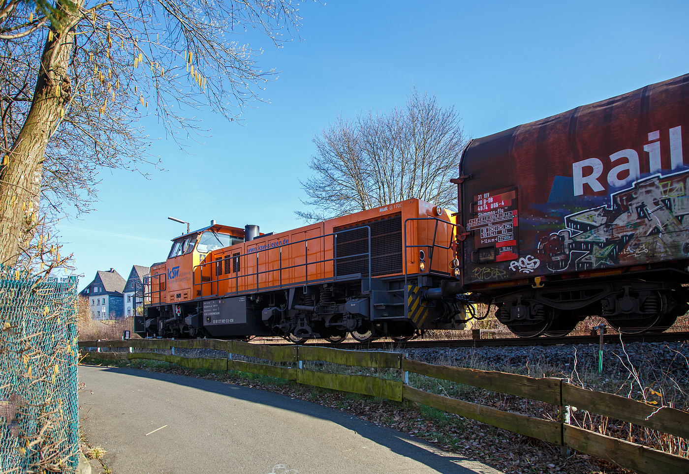 Die KSW 42 (92 80 1277 902-3 D-KSW), eine Vossloh MaK G 1700 BB, drückt am 03.03.2023, weitere leere Güterwagen vom Rangierbahnhof der KSW in Herdorf (Freien Grunder Eisenbahn KSW NE447 / DB-Nr. 9275), in den Bahnhof Herdorf. Im Bahnhof steht bereit die KSW 46 (277 807-4) mit dem ersten Teil von dem Übergabe-Güterzug. Beide Zugteile werden dort dann aneinander gekuppelt und im Sandwich (Vorne die KSW 42 und am Zugschluss die KSW 46), fahren sie dann nach Dillenburg. 

Eigentlich würde sie einfach via Betzdorf nach Kreuztal fahren, aber der Abschnitt Herdorf – Betzdorf bleibt, nach dem Felssturz am 23.12.2022 in Herdorf, bis voraussichtlich zum kleinen Fahrplanwechsel am 09. Juni 2023 gesperrt.