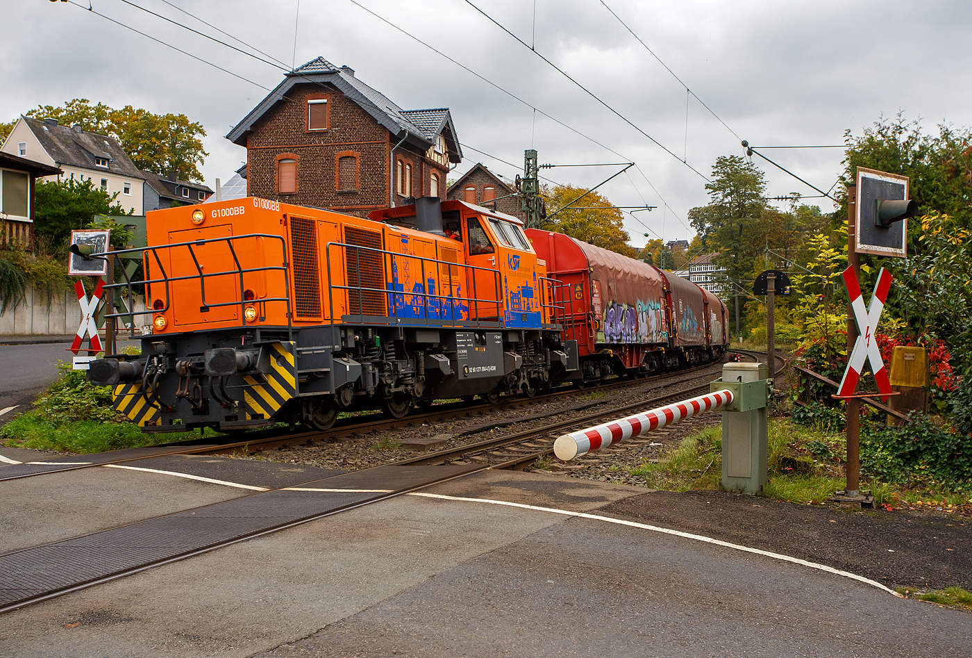 Die KSW 44 (92 80 1271 004-4 D-KSW) eine MaK G 1000 BB der KSW (Kreisbahn Siegen-Wittgenstein) fährt am 09 Oktober 2025, mit einem Coilzug, beim Bü km 121,192 durch Kirchen/Sieg in Richtung Betzdorf/Sieg.

In Betzdorf/Sieg setzt die Lok dann um und es geht dann über die Hellertalbahn (KBS 462) nach Herdorf. 

Die Lok 44 wurde 2003 unter der Fabriknummer 1001462 bei Vossloh gebaut und am 05.01.2004 an die damalige SK - Siegener Kreisbahn GmbH geliefert, welche ab Ende 2004 nun als Kreisbahn Siegen-Wittgenstein (KSW) firmiert.