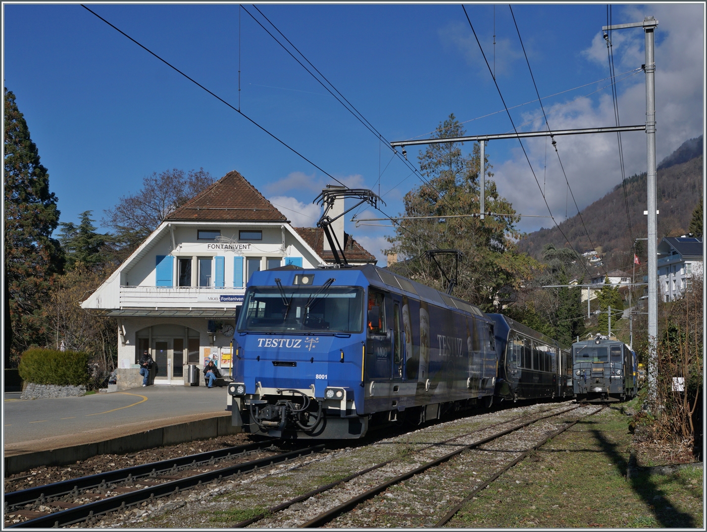 Die MOB Ge 4/4 8001 fährt mit ihrem GoldenPass Express GPX 4074 von Montreux nach Interlaken Ost durch den Bahnhof von Fontanivent. Im Hintergrund ist die GDe 4/4 6002 abgestellt.

13. Februar 2024