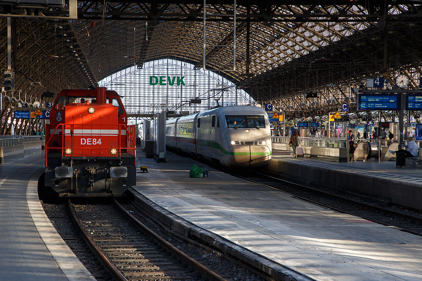 Die RheinCargo DE 84 (98 80 0272 022-1 D-RHC), ex HGK DE 84, eine MaK DE 1002, sowie ein ICE 2 verlassen am 14 Mai 2022 den Hauptbahnhof Köln.