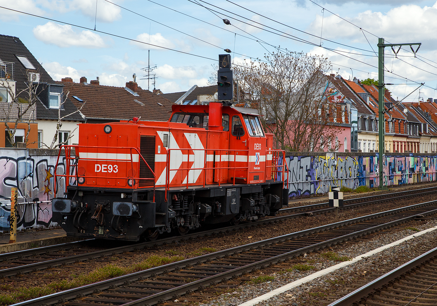 Die RheinCargo DE 93 alias 272 011-4 (98 80 0272 011-4 D-RHC), eine MaK DE 1002 der RheinCargo fährt am Sonntag den 30.04.2023 als Lz (Lokzug) bzw. auf Tfzf (Triebfahrzeugfahrt) durch den Bahnhof Köln-Ehrenfeld in Richtung Köln-Nippes.

Die Lok wurde 1986 von der Krupp-MaK Maschinenbau GmbH in Kiel unter der Fabriknummer 1000835 gebaut. 1999 wurde sie durch Adtranz (ABB Daimler Benz Transportation GmbH) in Kassel mit einem 12-Zylinder Dieselmotor vom Typ MTU 12V 4000 R20 remotorisiert, zum dem wurde die Leittechnik umgebaut.