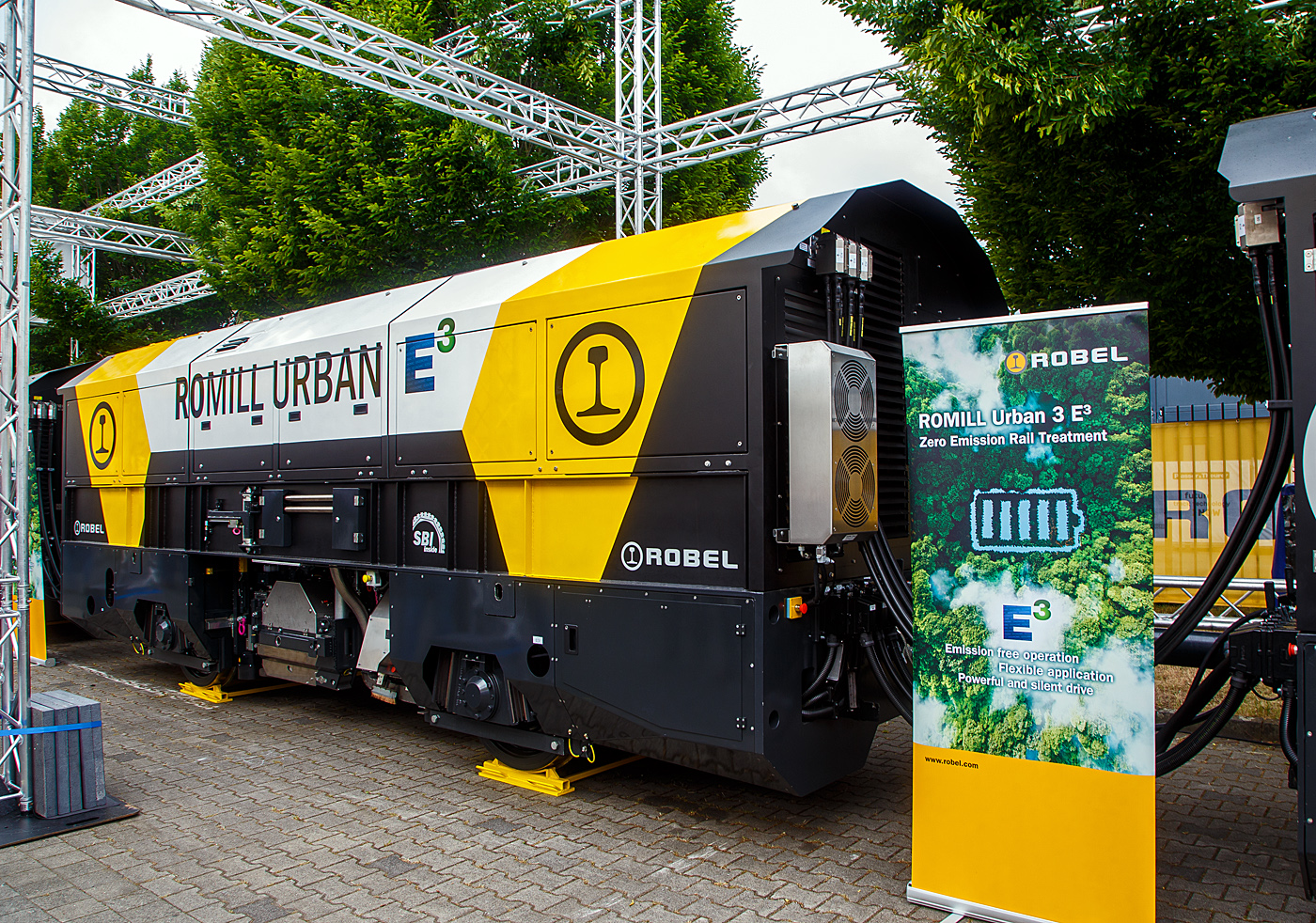 Die Robel Bahnbaumaschinen GmbH (Robel) pr�sentiert auf der 28. Internationale Ausstellung Fahrwegtechnik 2022 (iaf) in M�nster (hier am 31.05.2022) das dreiteilige Schienenbearbeitungssystem ROMILL Urban 3 E� f�r die Plasser American Corporation (PAC) mit Sitz in Chesapeake, Virginia. Die Lieferung soll im Sommer 2022 erfolgen. Das Schienenbearbeitungssystem ROMILL Urban E� ist ein gemeinsames Projekt von Robel, Schweerbau International GmbH & Co.KG (SBI) und Vogel & Pl�tscher GmbH & Co.KG, es ist die weltweit erste Hybrid-Fr�smaschine von Robel.

Hier das mittlere 2. Wagenteil (Segment) mit der Bearbeitung-/ Fr�stechnik.
