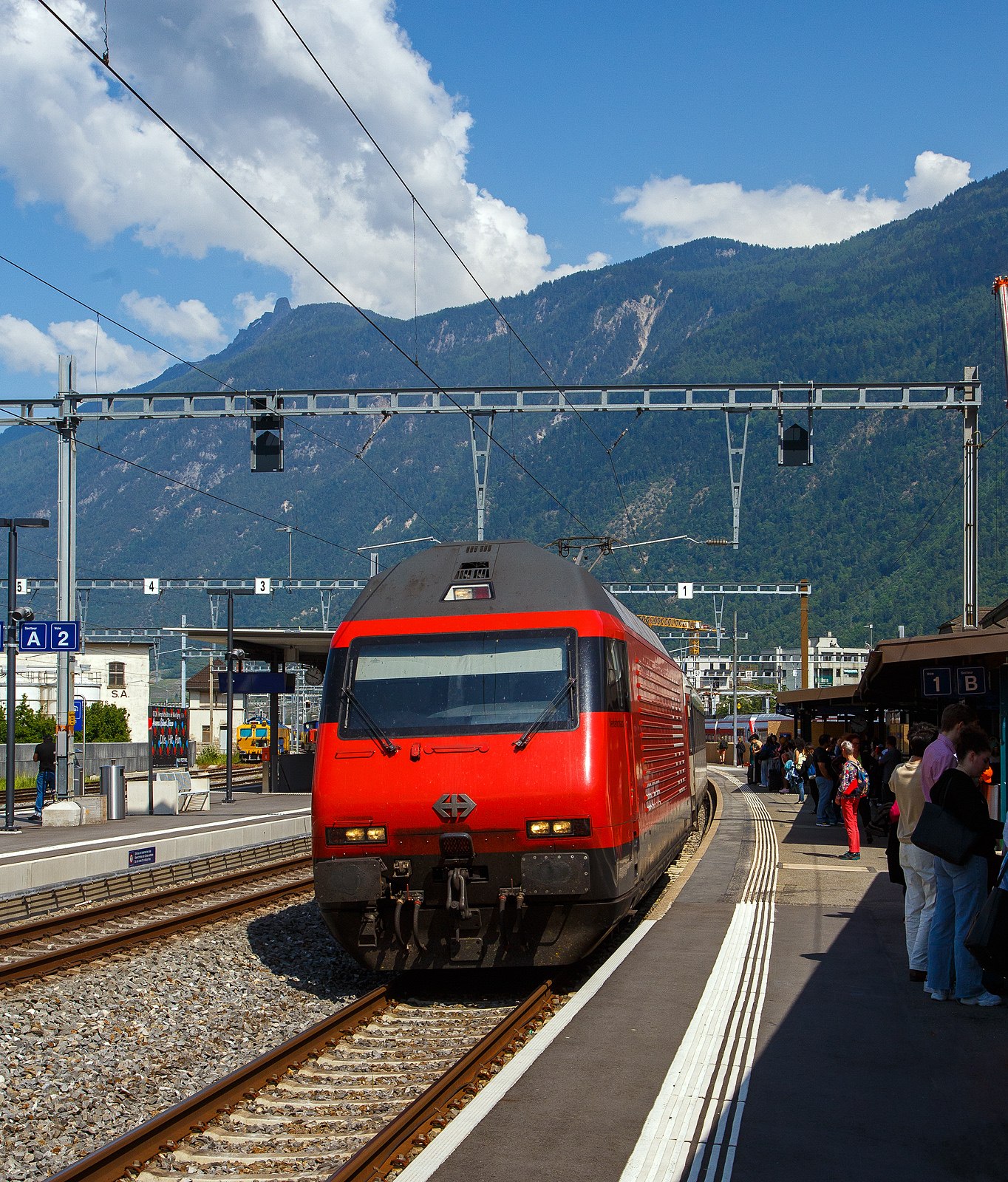 Die SBB Re 460 069-8  Verkehrshaus  (91 85 4 460 069-8 CH-SBB) fährt am 26 Mai 2023, mit dem IR 90 von Brig nach Genève-Aéroport (Umlauf IR 1724), in den Bahnhof Martigny ein. Da der Zug recht lang war wurde im Sandwich gefahren, so war am Zugschluss die SBB Re 460 041-7  Mendrisiotto .

Die Re 460 069-8 wurde 1993 von der SLM (Schweizerischen Lokomotiv- und Maschinenfabrik in Winterthur) unter der Fabriknummer 5542 gebaut, der elektrische Teil ist von der ABB (Asea Brown Boveri).
