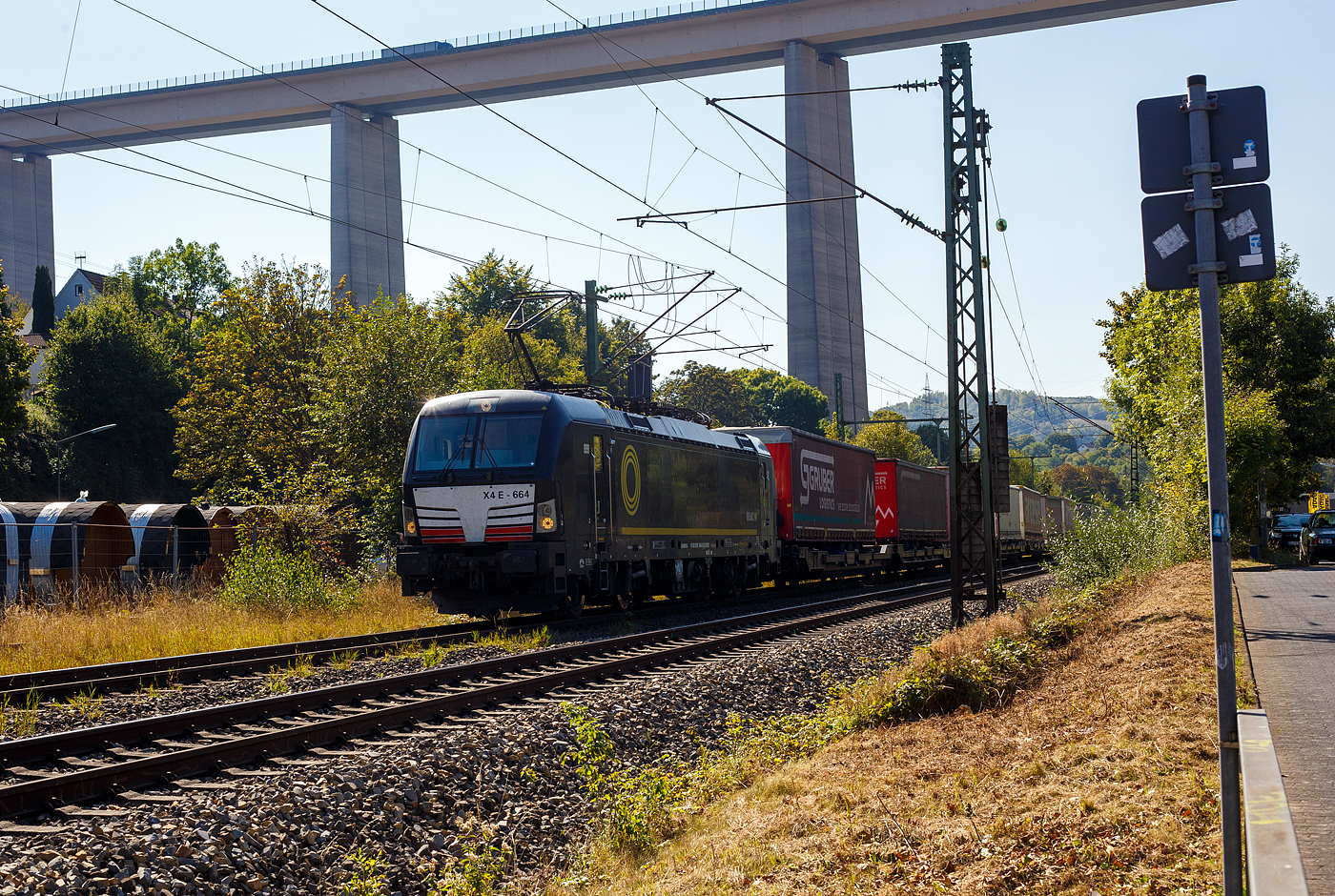 Die SIEMENS Vectron MS X4E – 664 / 193 664-0 (91 80 6193 664-0 D-DISPO) der BRCE - Beacon Rail Capital Europe (München) fährt am 21 September 2024 mit einem KLV-Zug durch Eiserfeld in Richtung Siegen. 

Die Multisystemlokomotive Siemens Vectron MS wurde 2017 von Siemens Mobilitiy in München-Allach unter der Fabriknummer 22244 gebaut. Sie wurde in der Variante A09 (Zulassungen für D / A / I) ausgeführt. Im Jahr 2022 erfolgte bie Siemens in München-Allach der Umbau in die Variante A22 und hat so die Zulassung für Deutschland, Österreich, die Schweiz, Italien und die Niederlande (D / A / CH / I / NL). So besitzt die Variante MS A22 folgende Zugsicherungssysteme: ETCS BaseLine 3, sowie für Deutschland (PZB90 / LZB80 (CIR-ELKE I)), für Österreich (ETCS Level 1 mit Euroloop, ETCS Level 2, PZB90 / LZB80), für die Schweiz (ETCS Level 2, ZUB262ct, INTEGRA), für Italien (SCMT) und die Niederlande (ETCS Level 1, ETCS Level 2, ATB-EGvv)

Die Lok wurde an die MRCE - Mitsui Rail Capital Europe GmbH in München ausgeliefert, seit September 2023 hat die Beacon Rail Metro Finance B.V. die Mitsui Rail Capital Europe B.V. (Amsterdam) und somit auch die Mitsui Rail Capital Europe GmbH im München übernommen, so firmiert sie nun als Beacon Rail Capital Europe GmbH, München (BRCE / DISPO).
