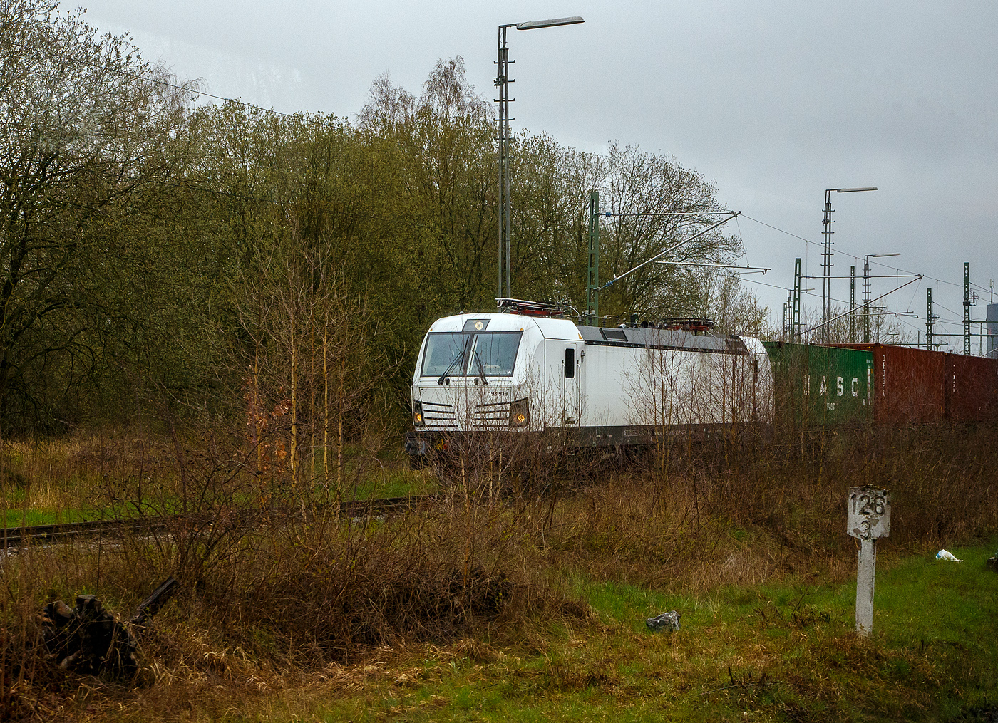 Die weiße SIEMENS Vectron AC DPM 193 919 (91 80 6193 919-8 D-ELOC) am 17.04.2023 mit einem Containerzug beim Hbf Hof. Bild aus einem Zug heraus.

Die SIEMENS Vectron AC DPM mit Diesel Power Modul  bzw. LM (Last Mile Diesel) wurde 2022 von Siemens Mobilitiy in München-Allach unter der Fabriknummer 22968 gebaut. Diese Vectron Lokomotive ist als AC DPM – Lokomotive (Wechselstrom-Variante mit Dieselmodul für Rangieren ohne Fahrdraht) mit 6.400 kW konzipiert und zugelassen für Deutschland, Österreich Ungarn und Rumänien (D/A/H/RO), im Dieselbetrieb beträgt die Leistung lediglich 180 kW (160 kW am Rad).