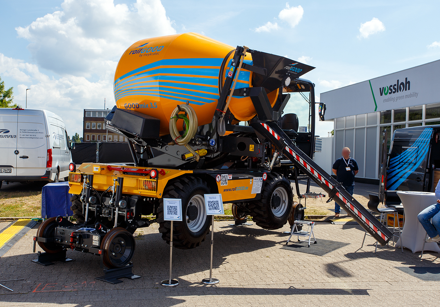 Die Weltneuheit im Gleisbau, der erste 2-Wege-Betonfahrmischer
Die railGOOD by Meykratec aus Bad Rothenfelde pr�sentierte auf der 29. Internationale Ausstellung Fahrwegtechnik 2025 (iaf) in M�nster (hier am 20 Mai 2025) den GOODmix 3,5, einen Betonmischer mit Schienenfahrwerk. Eine Innovation auf die die Welt des Gleisbaus gewartet hat. Zugelassen ist er als Gleisfahrende Baumaschine G 9901 001 (Art: Zweiwege-Betonmischer GOODmix 3,5). Ich finde ein sehr gelungenes Ger�t. 

Das Schienenfahrwerk des GOODmix 3,5 erm�glicht es dem Betonmischer sich m�helos auf den Gleisen zu bewegen, ohne dabei aufw�ndige Transportl�sungen oder zus�tzliche Maschinen zu ben�tigen. Dies spart nicht nur Zeit und Kosten, sondern erh�ht auch die Flexibilit�t und Produktivit�t auf der Baustelle. 

Dank seiner robusten Bauweise und leistungsstarken Mischtrommel liefert der GOODmix 3,5 zuverl�ssig eine gleichm��ige und hochwertige Betonmischung, die den Anforderungen des Gleisbaus in jeder Hinsicht gerecht wird. 

Das Basisfahrzeug ist ein DIECI Fahrmischer vom Typ AB L 4700 T des italienischen Herstellers Dieci s.r.l. aus Montecchio Emilia. Das Schienenfahrwerk ist vom niederl�ndischen Hersteller AMT aus Breda. Idee Entwicklung sind von railGOOD by Meykratec aus Bad Rothenfelde, die auch den Alleinvertrieb hat. 

Das Fahrzeug:
Der hydrostatische Antrieb mit Verstellpumpe, gew�hrleistet fl�ssige und genaue Bewegungen. Der unabh�ngige Hydraulikkreis f�r die Trommeldrehung garantiert maximale Mischleistungen. Die Mischtrommel verf�gt zur einfacheren Entleerung �ber eine Hubeinrichtung, sowie ein 180�-Drehsystem f�r eine dreiseitige Entleerung. Die Fahrerkabine, die sich hinsichtlich Ergonomie, Komfort und Sicherheitsausstattungen im gehobenen Segment ansiedelt, ist mit einem umkehrbaren Fahrerstand ausgestattet, so kann der Fahrer immer in Fahrtrichtung sitzen.

Technische Merkmale:
Abmessungen in Transportstellung 5.825 x 2.400 x 3.140 mm
Eigengewicht: ca. 9.500 kg
Max. Nutzlast: 5.000 kg
Inhalt Wassertank: 630 l

Dieselmotor: Wassergek�hlter 4 Zylinder Perkins-Dieselmotor mit Turbolader und Ladeluftk�hlung, sowie Direkteinspritzung, vom Typ 904J-E36TA (Stage V)
Motorleistung: 85,6 kW (116 PS) bei 2.200 U/min
Maximales Drehmoment: 566 Nm – 1.500 U/min
Motorhubraum: 3,621 l (Bohrung � 98 mm x 120 mm Hub)
H�chstgeschwindigkeit Offroad: 27 km/h 

Auf der Schiene:
Inbetriebnahme: 07.01.2025
Spurweite: 1.435 mm (Normalspur)
H�chstgeschwindigkeit: 19,5 km/h (in Arbeitsstellung 5 km/h)
Zur Mitfahrt zugelassene Personen: 1 (Fahrer + 1 Rangierbegleiter)
Zugelassene Streckenklasse: A und h�her
Laufraddurchmesser: 500 mm (neu)
Hydraulische Bremse auf allen vier Eisenbahnr�der im Laufwerk
Federspeicherbremsen auf allen vier Eisenbahnr�der im Laufwerk Durchmesser Schienenrad 500 mm
Max. Rampenwinkel 13,5�
Max. �berh�hung 200 mm
Fahrgeschwindigkeit Gleis Stufe 1 bis 9, Stufe 1 bis 2 9-19,5 km/h
Fahrgeschwindigkeit Offroad 27 km/h
