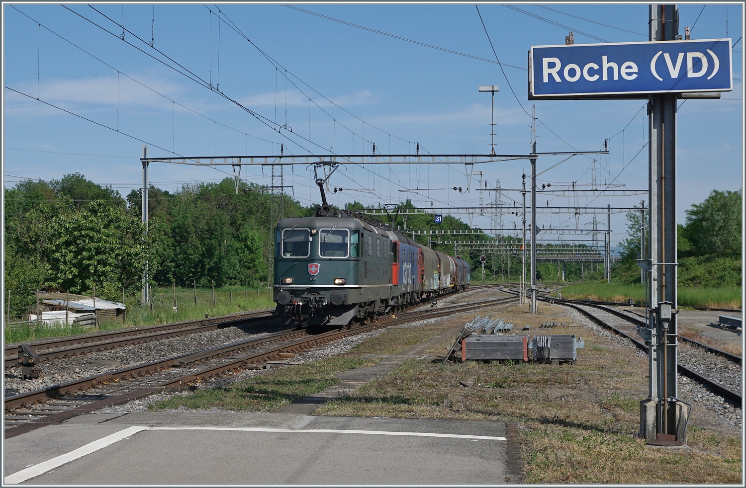 Die wieder in Grün lackierte SBB Re 4/4 II 11335 (Re 420 335-2) fährt mit einer Re 6/6 und einem kurzen Güterzug durch die Station Roche (VD) in Richtung Wallis.

12. Mai 2022 